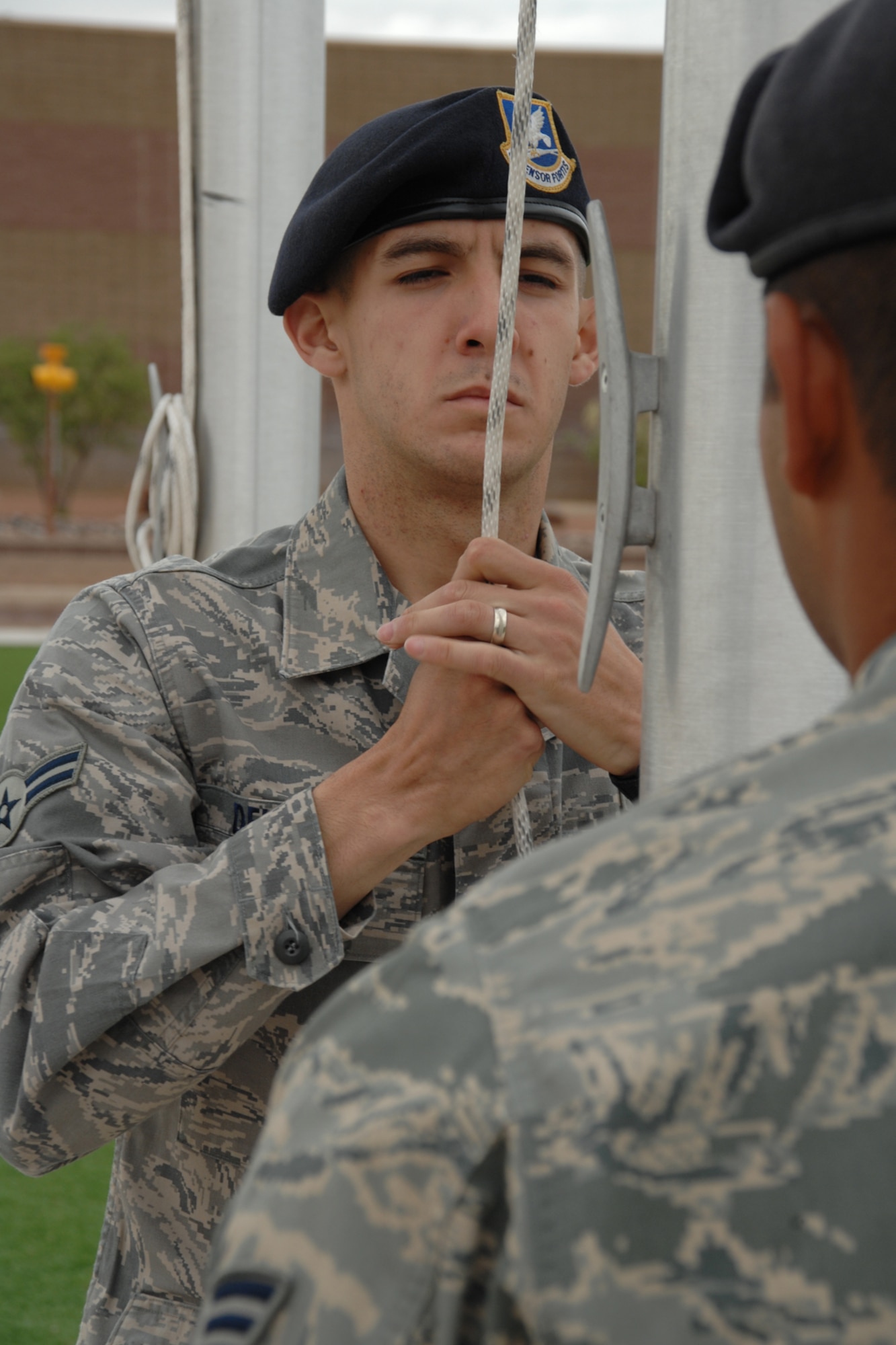 Airman 1st Class Ricardo Delgado, with the assistance of Senior Airman Roy Hernandez, both from the 49th Security Forces Squadron,  raise the American flag to full staff during a National Police Week Remembrance ceremony May 16 at Holloman Air Force Base, N.M. National Police Week is a solemn period where law enforcement personnel, both civilian and military, reflect on those who have fallen. (U.S. Air Force photo/Airman 1st Class Jamal D. Sutter)