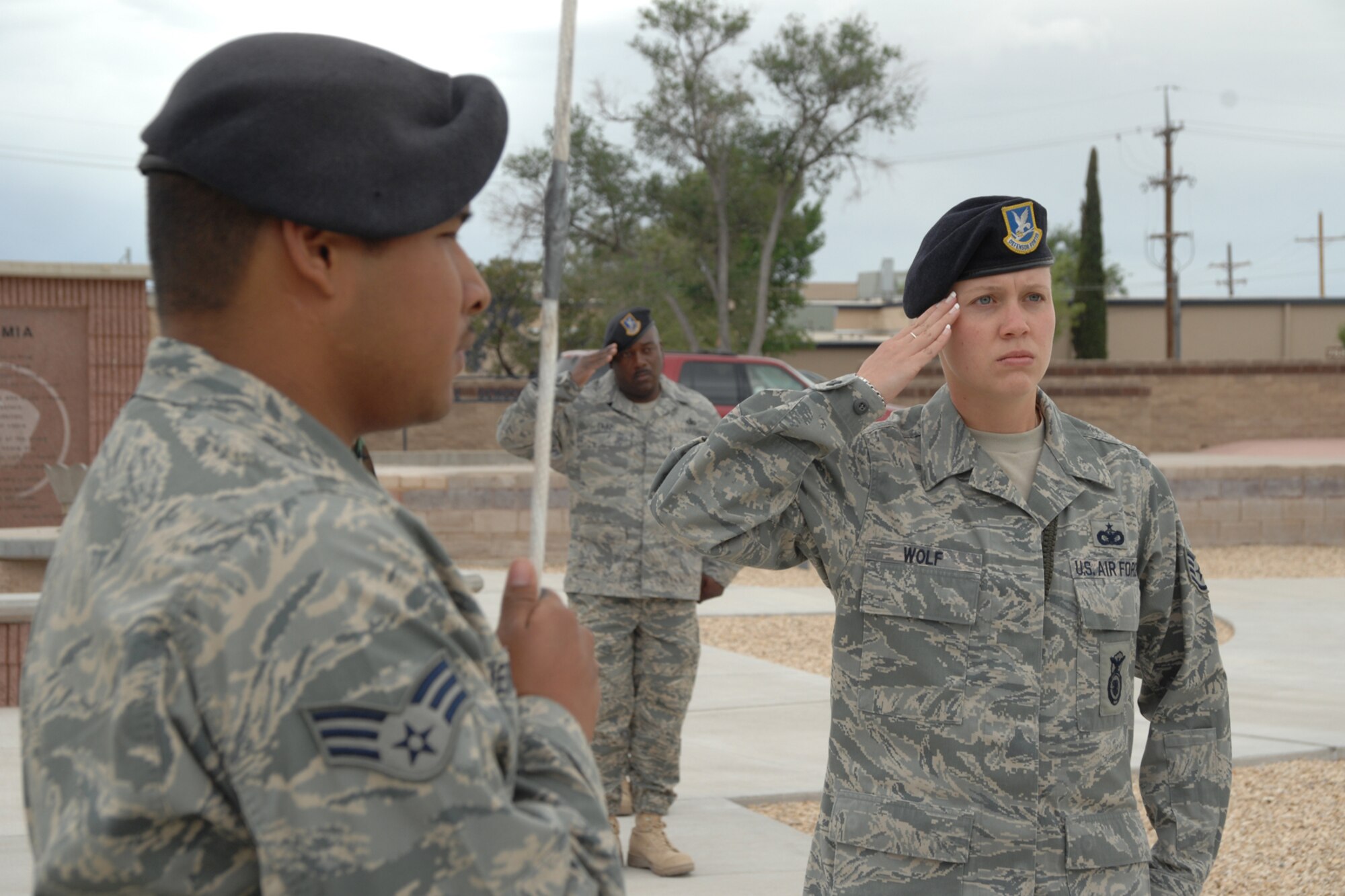 Staff Sgt. Beth Wolf, 49th Security Forces Squadron, salutes as Senior Airman Roy Hernandez, 49 SFS, raises the nation's flag to full staff during a National Police Week Remembrance ceremony May 16 at Holloman Air Force Base, N.M. The yearly ceremony is an event held to honor fallen law enforcement personnel, both civilian and military. (U.S. Air Force photo/Airman 1st Class Jamal D. Sutter)
