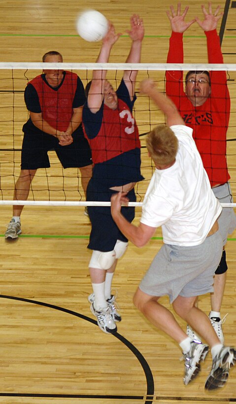 Kenneth Lechtenberg and David Olsen, 28th Civil Engineer Squadron intramural volleyball team members, attempt to block an attack by a Detachment 8 team member during the intramural volleyball championship series at the Bellamy Fitness Center, May 19. The 28 CES team defeated Det. 8 30-21 in both games of a best-of-three series sealing an undefeated season as the base champions.  (U.S. Air Force photo/Staff Sgt. Eric Bolt) 