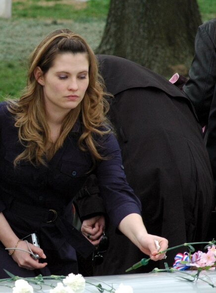Courtney Woods, granddaughter of former missing in action Airman Maj. Robert F. Woods, lays a flower on the casket of her grandfather during the funeral for Major Woods at Arlington National Cemetery April 9, 2008.  Major Woods, who was buried nearly 40 years after disappearing in Vietnam on June 26, 1968, was someone Ms. Woods never knew, but knows a lot about thanks to her grandmother, the major's wife, Mary Woods.  (U.S. Air Force Photo/Tech. Sgt. Scott T. Sturkol)