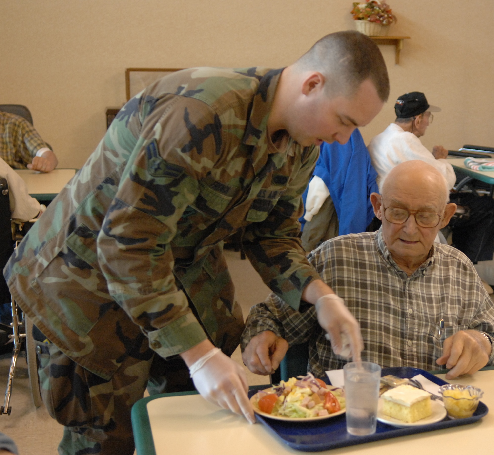 WARRENSBURG, Mo., - Airman 1st Class Matthew French, 509th Security Forces Squadron, serves lunch to a veteran at the Missouri Veterans Home May 21. The Whiteman Airmen’s Council set up the event. Sixteen members of Team Whiteman served lunch to the veterans. The Airmen’s Council’s next meeting is June 17 at 3:30p.m. at the community activities center. (U.S. Air Force photo/Airman 1st Class Stephen Linch)