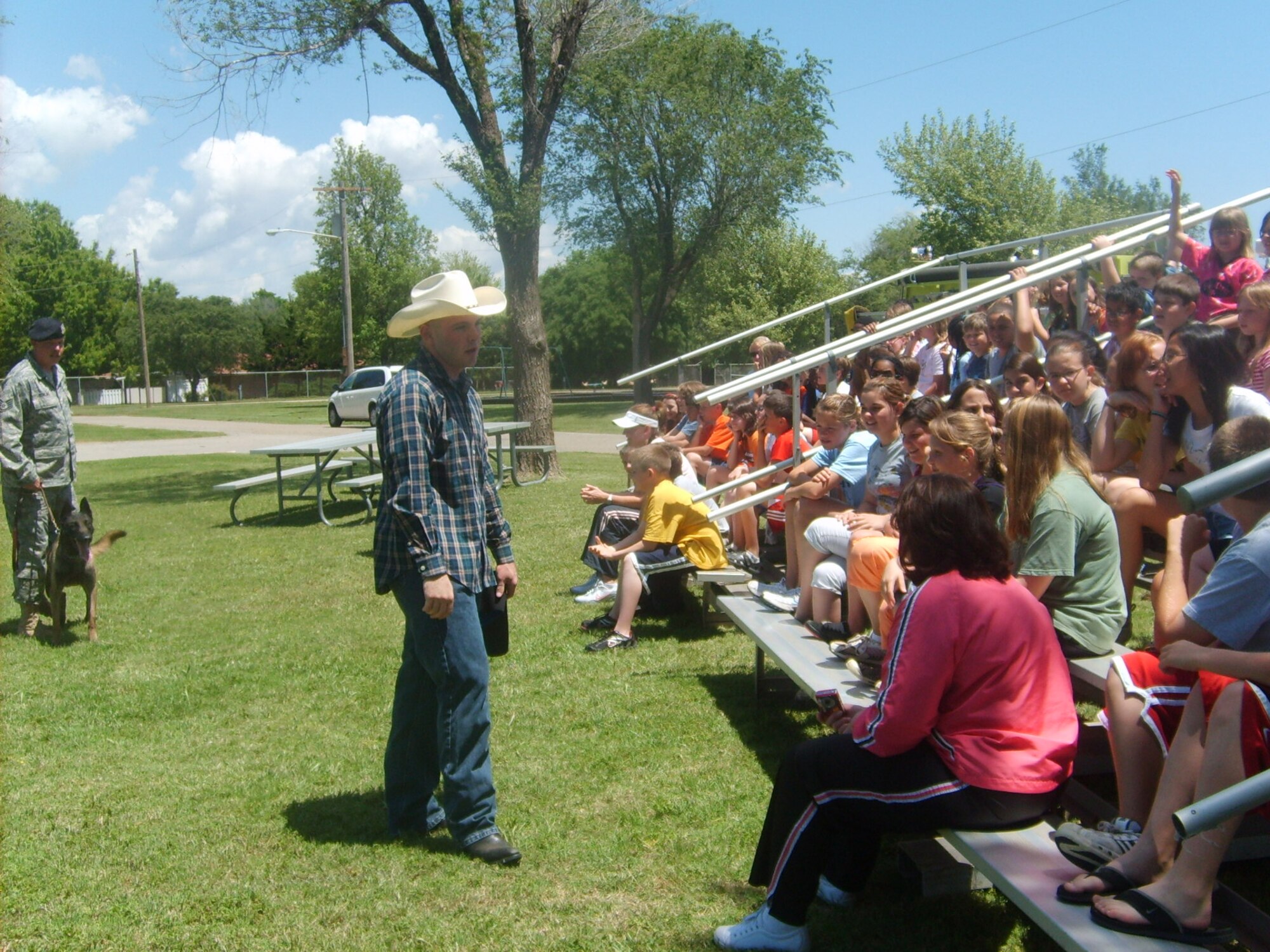 _____, 71st Security Forces Squadron, pretends he is a bandit on the loose. Staff Sgt. Bowling and dog ___ wait in the wings to take him down as part of a military working dog demonstration for Eisenhower Elementary school students