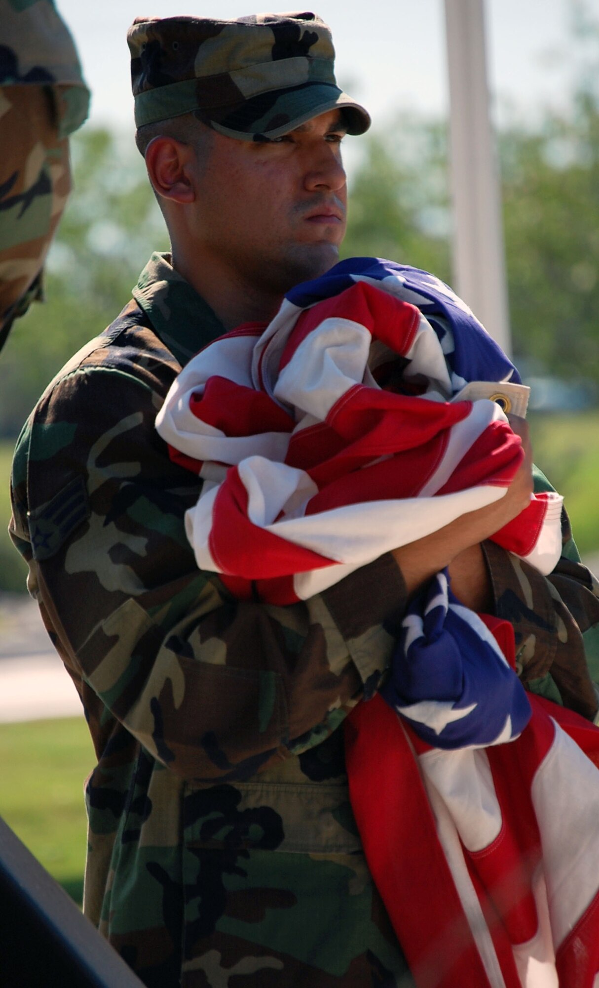 LAUGHLIN AIR FORCE BASE, Texas – Senior Airman Jonathan Griffith cradles the American flag after helping lower it during a retreat ceremony with his Airman Leadership Class here May 20. ALS classes perform retreat ceremonies before graduating as a part of course curriculum. (U.S. Air Force photo by Airman 1st Class Sara Csurilla)