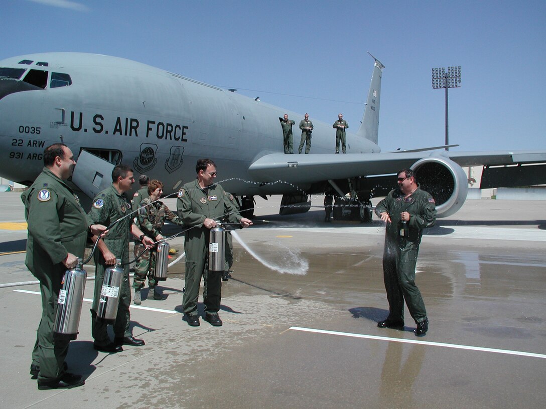 A squad of his comrades wet down Col. Greg "Happy" Gilmour after his final flight as a member of the 931st Air Refueling Squadron.  The wetdown for flyers' final flights is a military tradition.  Colonel Gilmour was selected to be the operations group commander for the 931st's parent wing, the 507th Air Refueling Wing at Tinker Air Force Base, Okla. (Courtesy photo)      