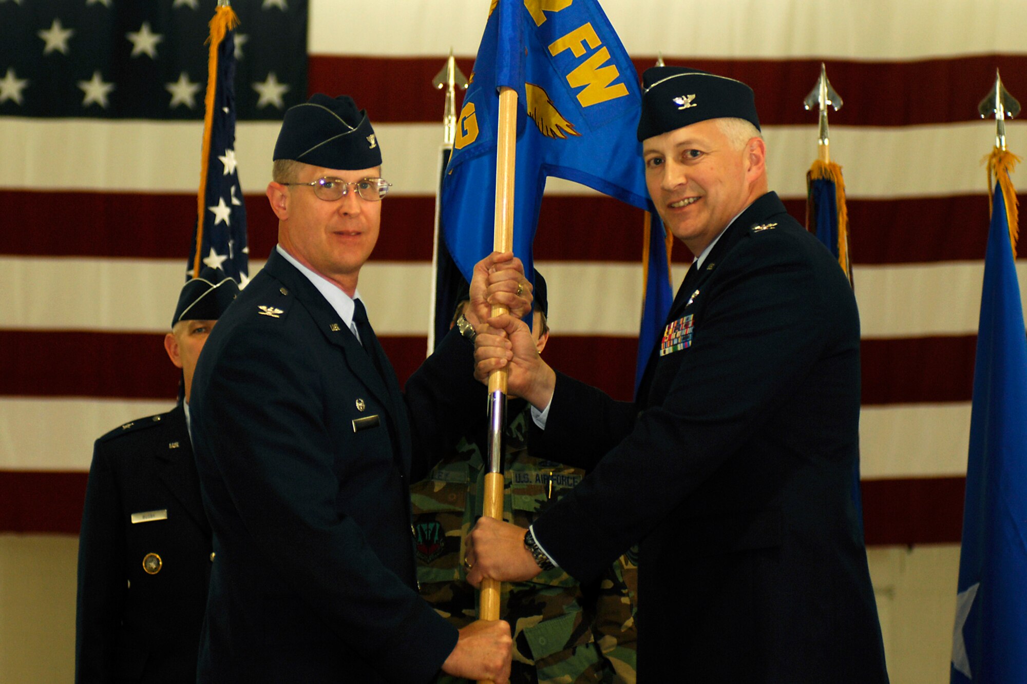 LANGLEY AIR FORCE BASE, Va. -- Col. Jay Pearsall (left), previous 192nd Fighter Wing commander, hands the unit flag to the new 192nd FW commander Col. Mark McCauley during a wing change of command here May 17.  (U.S. Air Force photo/Airman Gul Crockett)