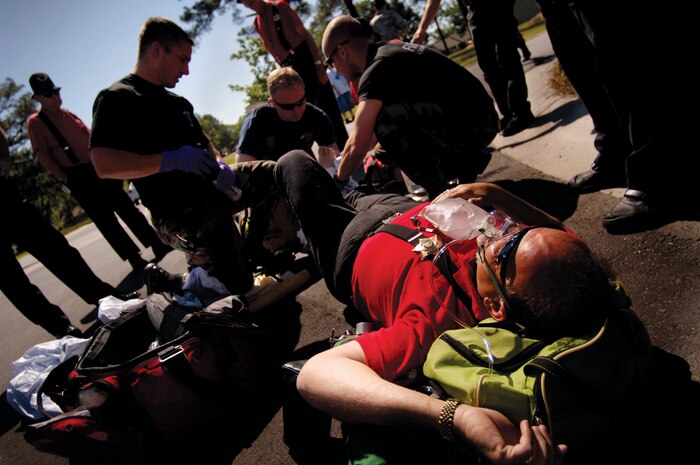 Staff Sgt. Brandon Voges, Christopher Lilkendey and Airman 1st Class Joseph Fournier treat Ronaldo Redondo for an injury he received during the Kids Candy Parade on the north side of housing at Charleston AFB May 17. Sergeant Vogus, Mr. Lilkendey and Airman Fournier are firefighters in the 437th Civil Engineer Squadron and Mr. Redondo is a performer in the "Omar Keystone Kops" of the Omar Shrine Temple, Mt. Pleasant, S.C.  (U.S. Air Force photo/Senior Airman Nicholas Pilch)