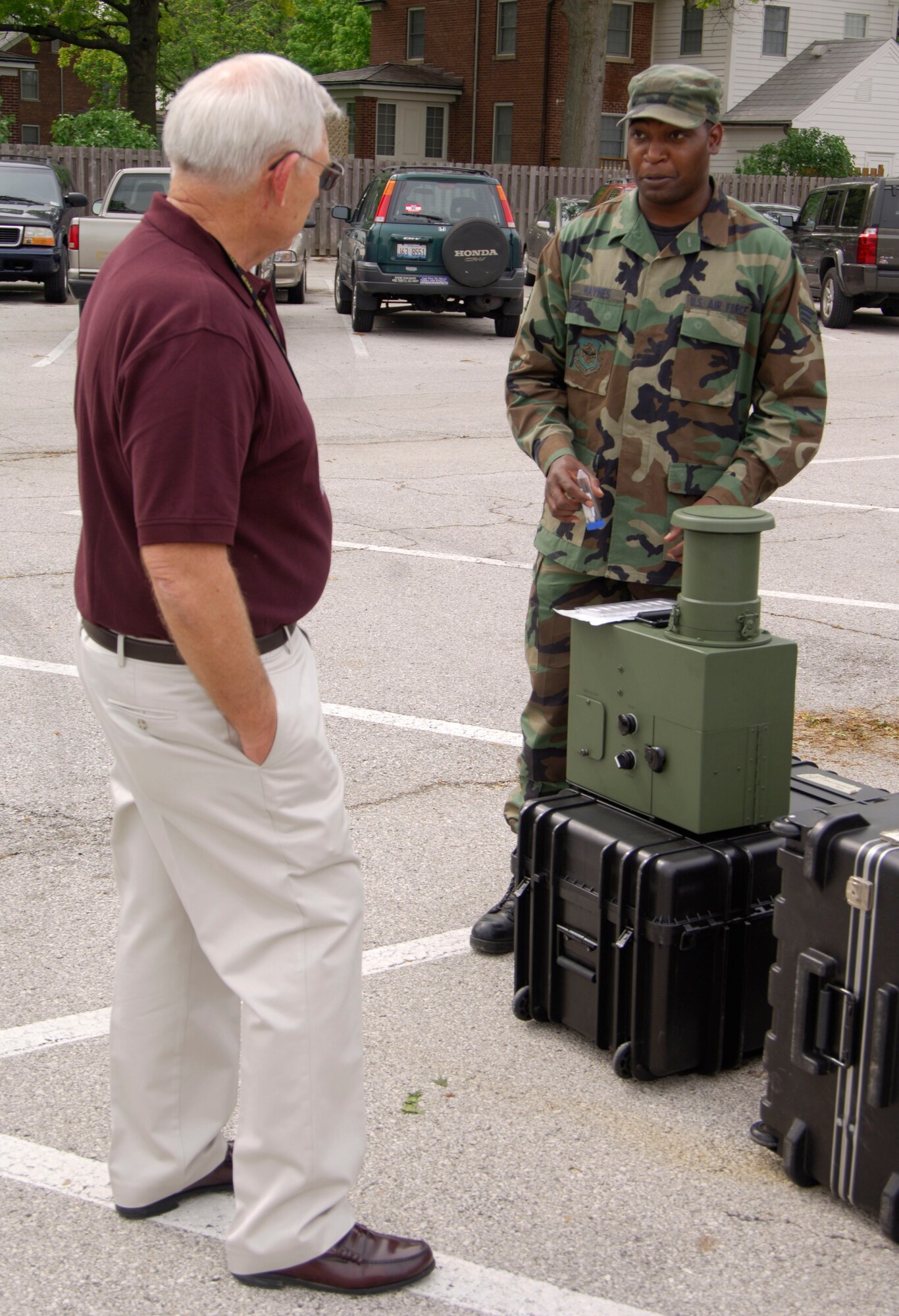 SCOTT AIR FORCE BASE, Ill. -- Donald Feher, St. Clair County assistant EMA manager, listens as Senior Airman Nyron Haynes, 375th Aerospace Medicine Squadron bioenvironmental engineer technician, explains the XMX Bio Aerosol Sample Collector. The machine is used by the Bio Environmental Engineering team to test the air for biological hazards. (U.S. Air Force photo/Airman 1st Class Wesley Farnsworth)