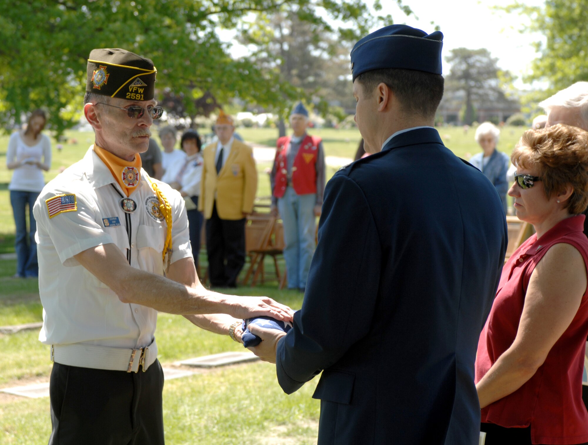 SEDALIA, Mo., - Joe Cochran, VFW Post 2591, presents an American flag to Col. John W. Robinson Jr., 509th Bomb Wing vice commander, following a folding ceremony. The folding of the flag was part of the 20th Annual Whiteman Memorial Wreath Laying Ceremony in Sedalia?s Memorial Park Cemetery. (U.S. Air Force/1st Lt. Matthew Miller)