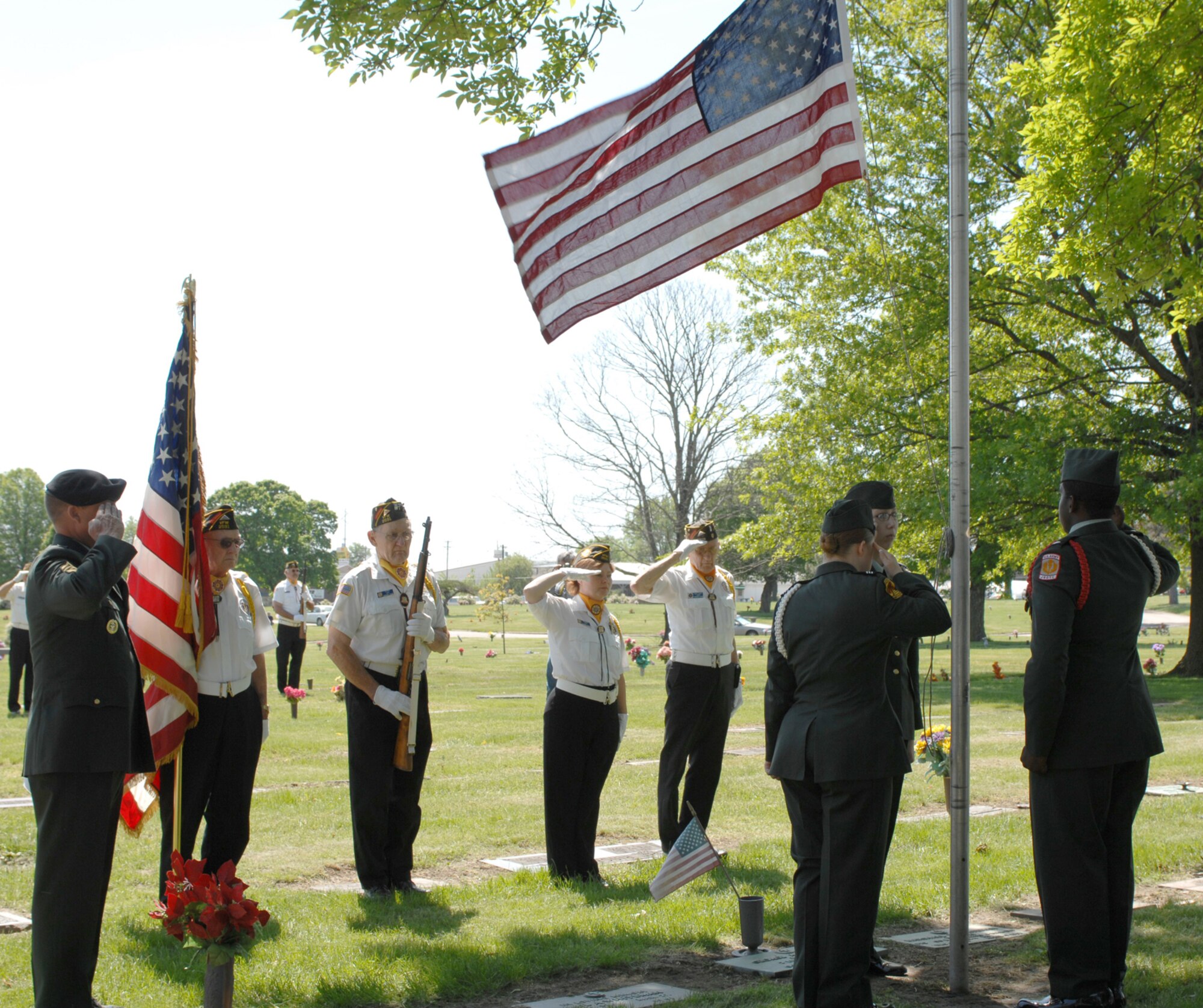 SEDALIA, Mo., - Members of VFW post 2591 render a salute as the Smith-Cotton High School JROTC Honor Guard lower the flag to half staff during the 20th Annual Whiteman Memorial Wreath Laying Ceremony in Sedalia's Memorial Park Cemetery. (U.S. Air Force/1st Lt. Matthew Miller)