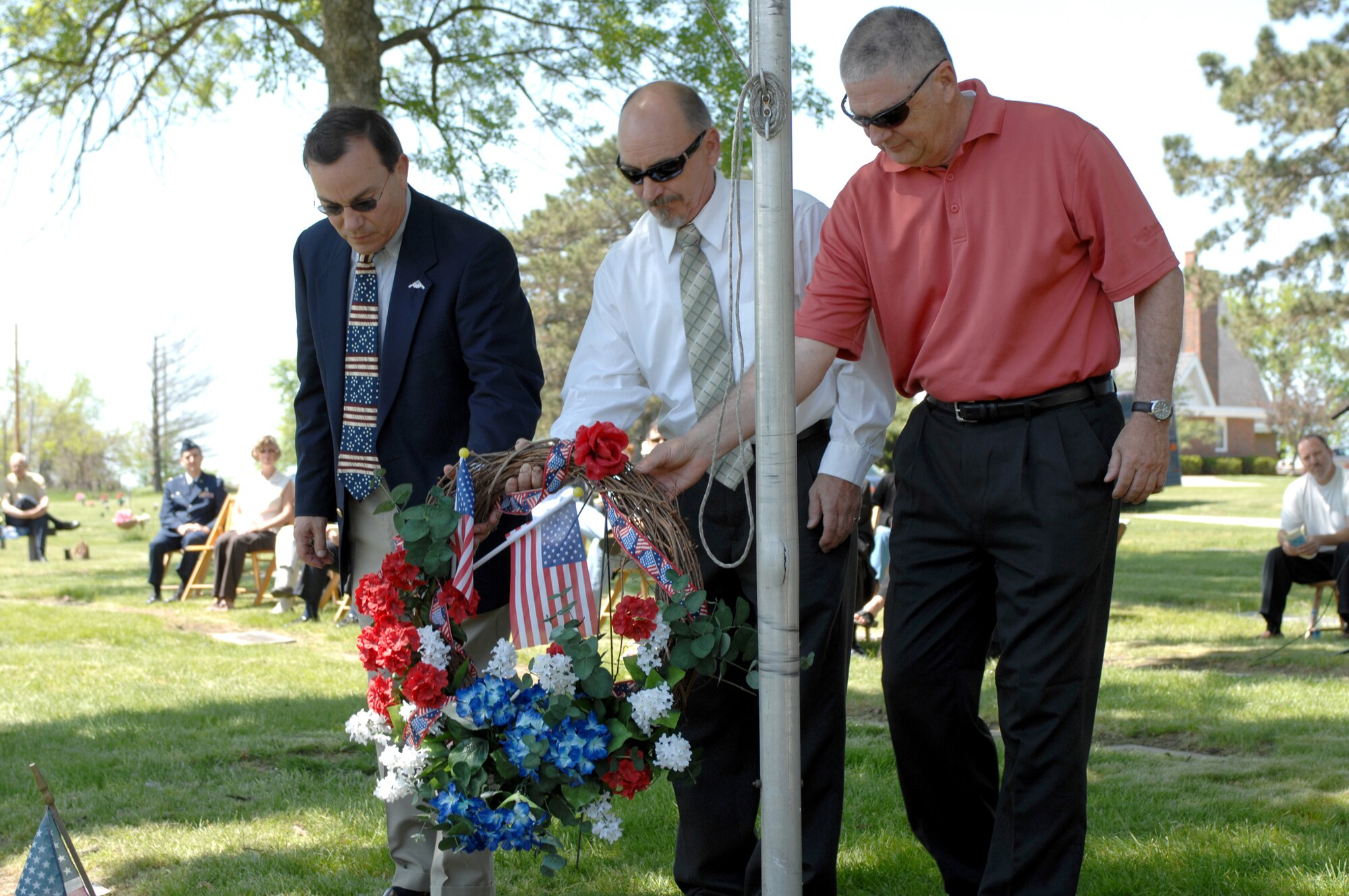 SEDALIA, Mo., - Nephews of 2nd Lt. George A. Whiteman, from left to right, Dr. Glenn Berry, Lake Tapawingo,Mo.; Dean Berry, Columbia, Mo. and George Williams, Bolivar, Mo., lay a wreath at Whiteman's grave marker at Memorial Park Cemetery in Sedalia May 17 to honor the fallen aviator who lost his life during the Japanese surprise attack on Pearl Harbor in 1941. The ceremony honored 2nd Lt. George A. Whiteman, a Sedalia native and the first American air casualty of World War II. (U.S. Air Force/1st Lt. Matthew Miller)