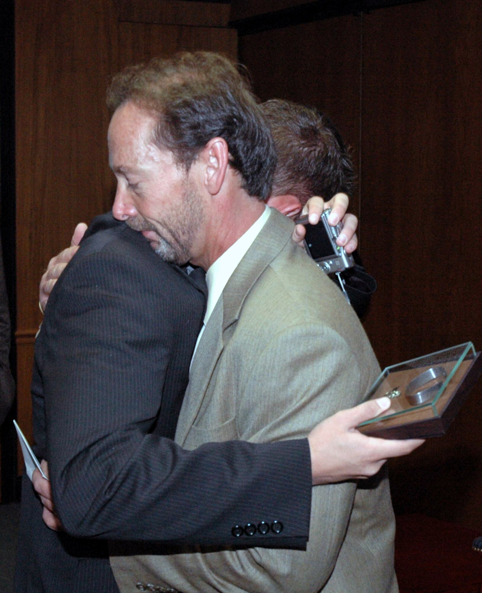 Mackenzie Woods hugs his father, Chuck Woods, after he was given a POW/MIA bracelet from his father at Arlington National Cemetery April 9, 2008.  The bracelet came from Maj. Phil Heseltine, executive officer to the U.S. Air Force Expeditionary Center commander at Fort Dix, N.J., who had previously presented the bracelet bearing the name of Maj. Robert F. Woods -- Chuck's father and Mackenzie's grandfather.  Major Heseltine wore the bracelet for 18 years and presented it to the family during the funeral for Major Woods April 9 at Arlington.  (U.S. Air Force Photo/Tech. Sgt. Scott T. Sturkol)