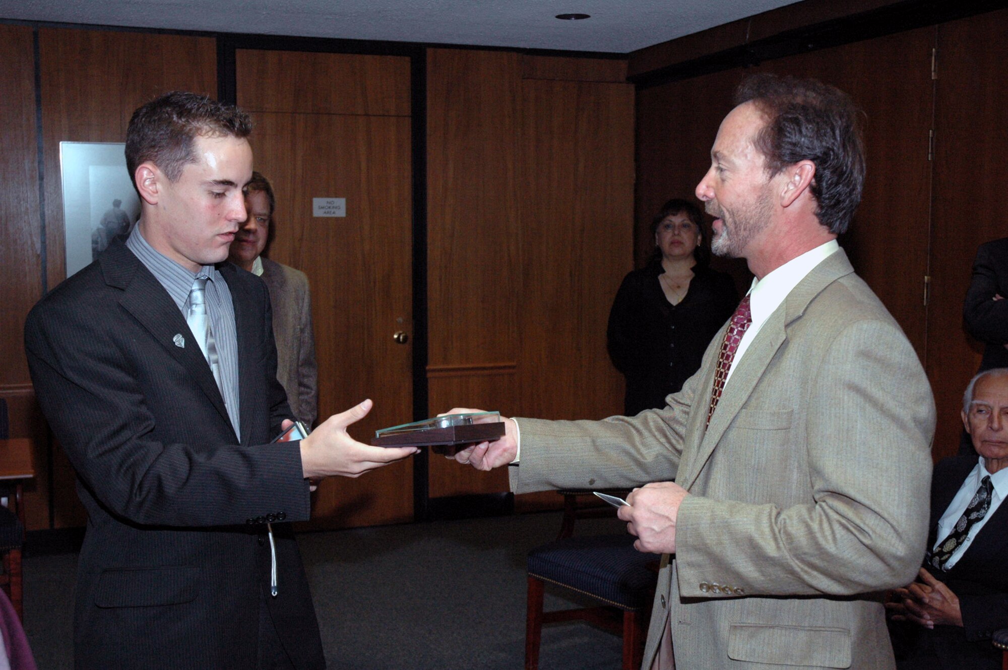 Mackenzie Woods accepts a POW/MIA bracelet from his father, Chuck Woods, at Arlington National Cemetery April 9, 2008.  The bracelet came from Maj. Phil Heseltine, executive officer to the U.S. Air Force Expeditionary Center commander at Fort Dix, N.J., who had previously presented the bracelet bearing the name of Maj. Robert F. Woods -- Chuck's father and Mackenzie's grandfather.  Major Heseltine wore the bracelet for 18 years and presented it to the family during the funeral for Major Woods April 9 at Arlington.  (U.S. Air Force Photo/Tech. Sgt. Scott T. Sturkol)