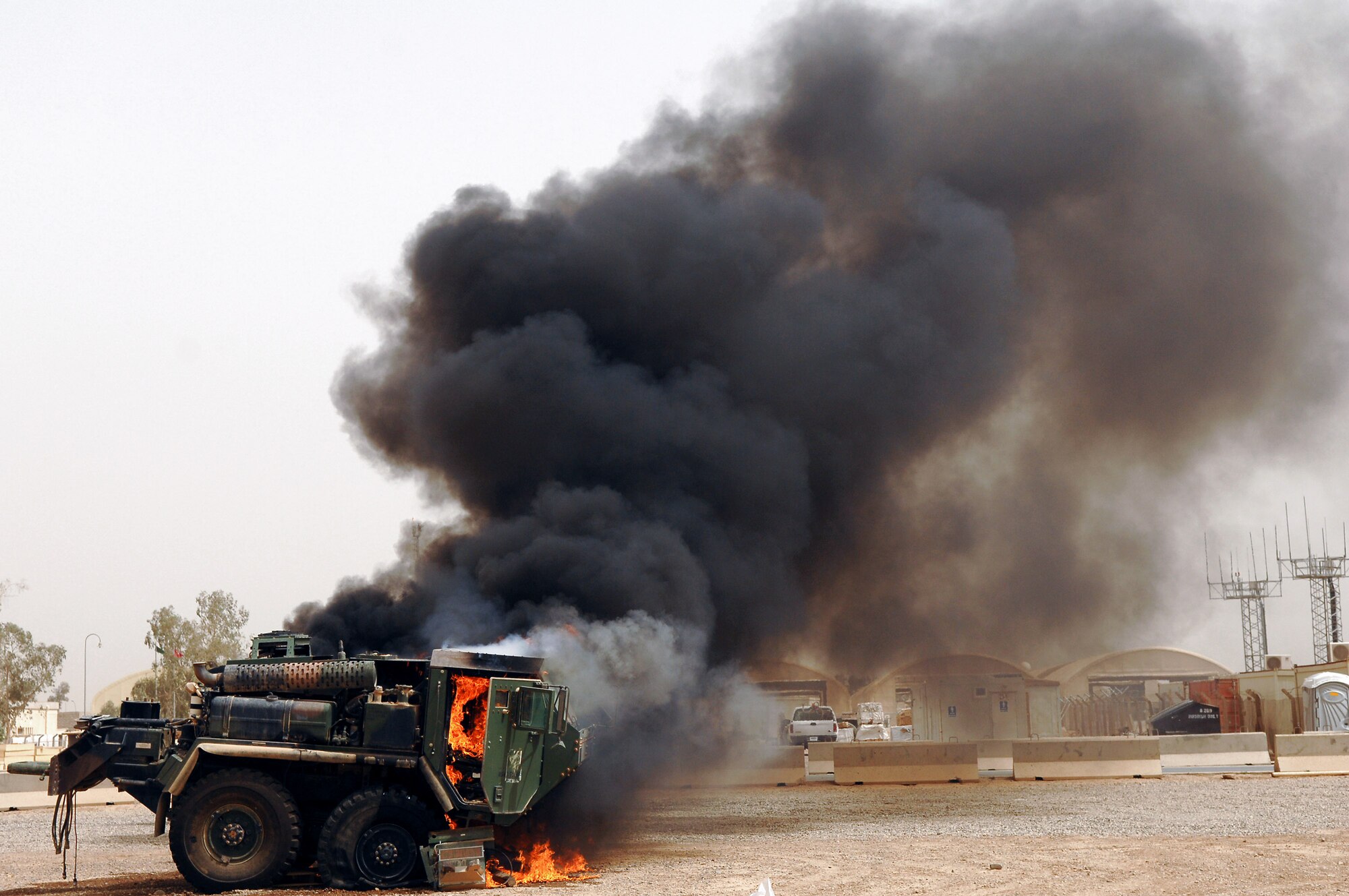 Members of the 332nd Expeditionary Civil Engineer Squadron and 8th Ordnance Company fire department set a vehicle on fire to practice practical application of combat fire suppression with bumper and roof-mounted turret hoses May 19 at Balad Air Base, Iraq. (U.S. Air Force photo/Senior Airman Julianne Showalter) 
