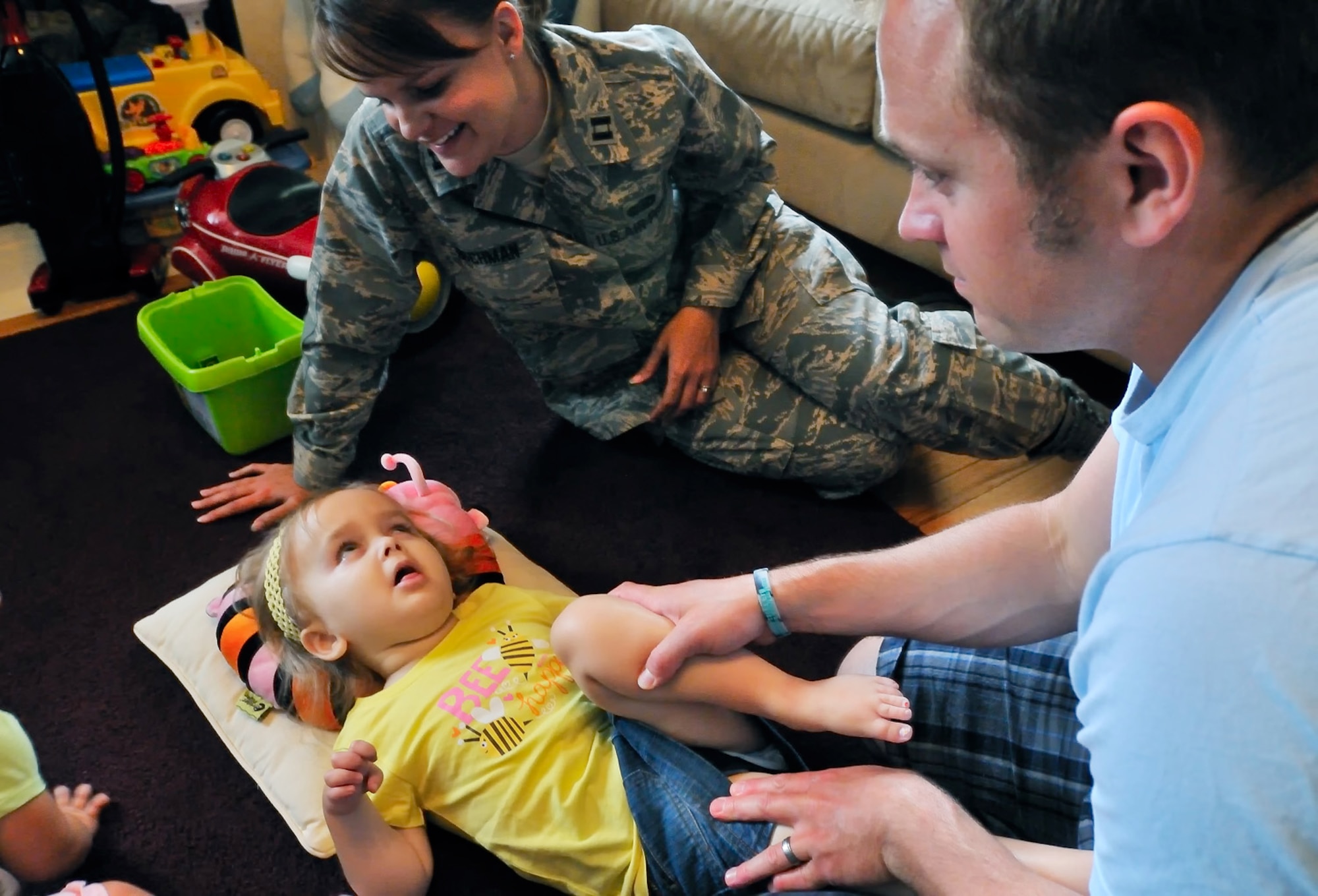 SCOTT AIR FORCE BASE, Ill. -- Capt. Kerri Rochman, 375th Mission Support Squadron chief of career development, watches her 3 1/2 year-old daughter Elise as her husband, Tim, performs their daily flexibility exercises on May 19. Elise was diagnosed more than two years ago with Tays-Sachs disease, an inherited incurable disease of the central nervous system. (U.S. Air Force photo/Master Sgt. Maurice Hessel)