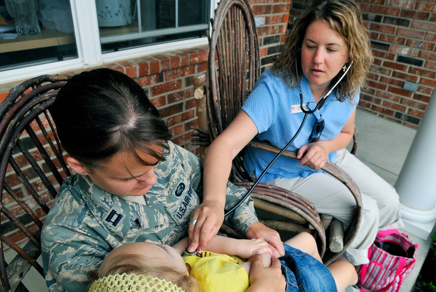 Capt. Kerri Rochman holds 3 1/2 year-old daughter Elise May 19 as registered nurse Deanna Sanvi takes her vital signs. Elise was diagnosed more than two years ago with Tays-Sachs disease, an inherited incurable disease of the central nervous system.  Captain Rochman is the 375th Mission Support Squadron chief of career development at Scott Air Force Base, Ill.  (U.S. Air Force photo/Master Sgt. Maurice Hessel)