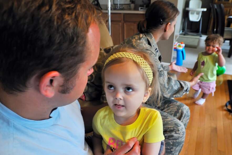 Elise looks at her dad Tim as Capt. Kerri Rochman entertains their 1 1/2 year old daughter Eden May 19. Elise was diagnosed more than two years ago with Tays-Sachs disease, an inherited incurable disease of the central nervous system. Captain Rochman is the 375th Mission Support Squadron chief of career development at Scott Air Force Base, Ill.  (U.S. Air Force photo/Master Sgt. Maurice Hessel)