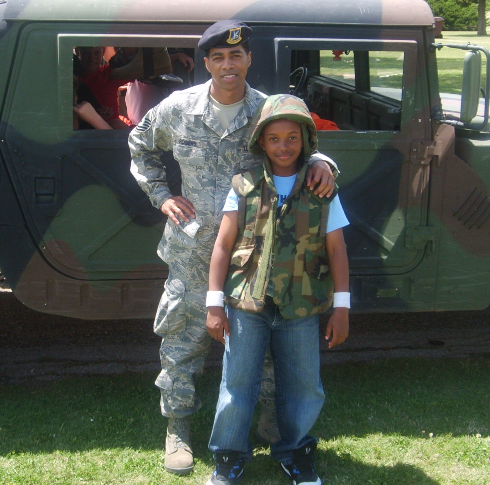 Chief Master Sgt. Tim Rogers, 71st Security Forces Squadron superintendent, shows Jahmir Clark, 9, son of Master Sgts. Joe and Carolyn Clark, how to properly wear protective gear for deployments. Jahmir and other Eisenhower Elementary School students attended Cops 4 Kids day at the Vance AFB base park. 