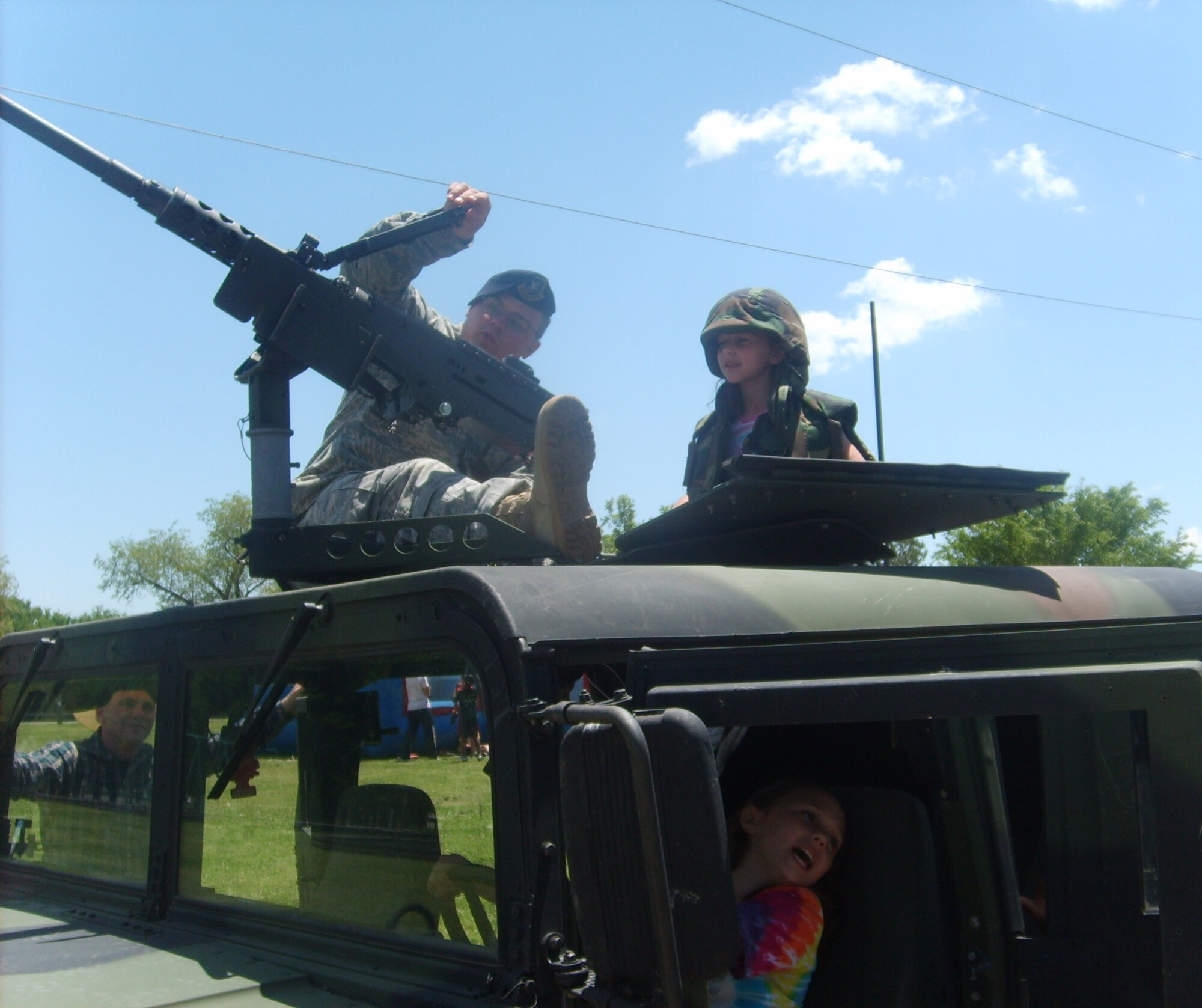 Senior Airman Jeffery Polzin of the 71st Security Forces Squadron here shows  children a 50 caliber machine gun mounted on a High Mobility Multipurpose Wheeled Vehicle at Vance's first "Cops 4 Kids" event at the base park. The event was part of National Police Week honoring the service of law enforcement personnel. (Courtesy photo)