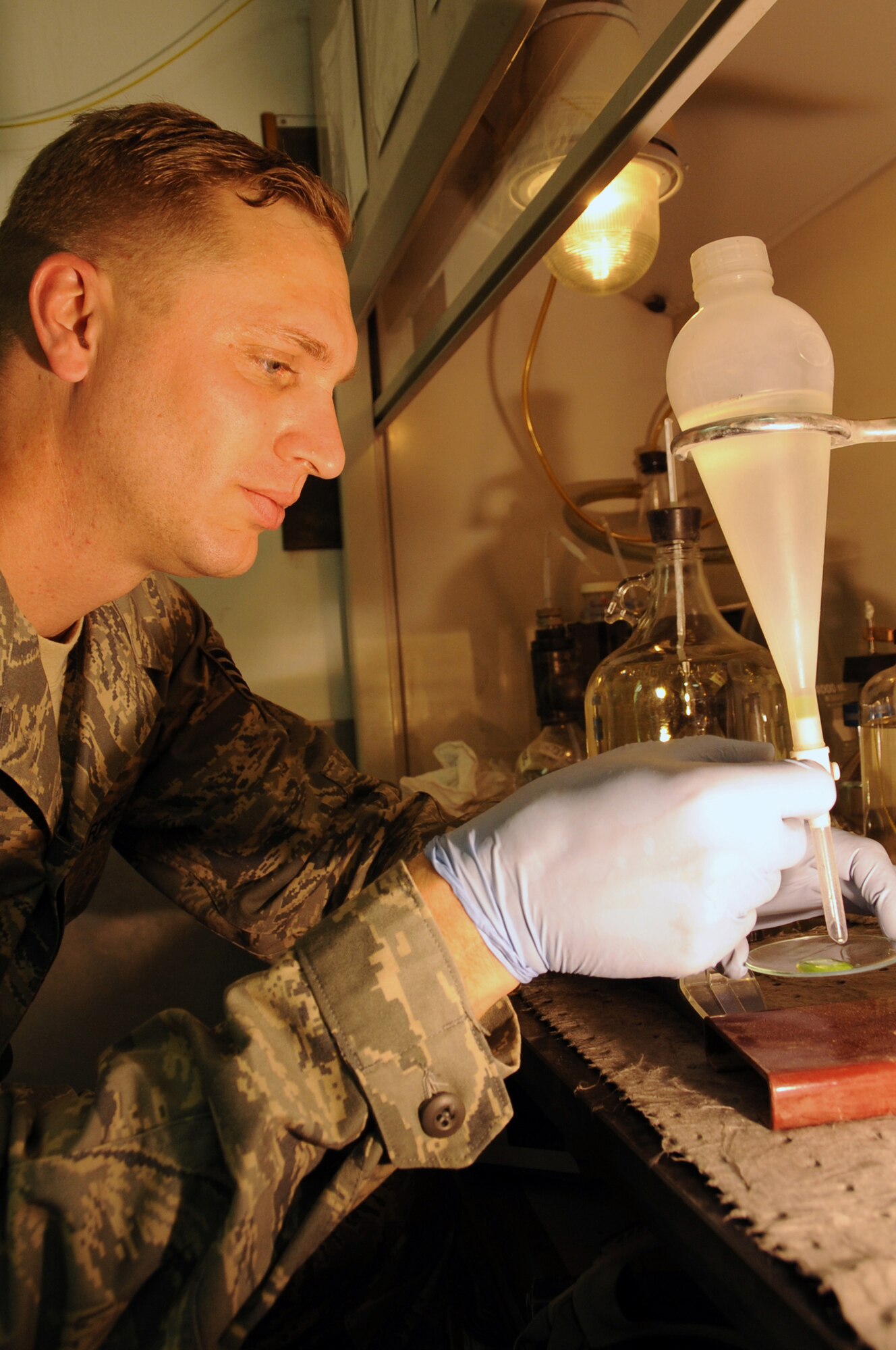 ALI BASE, Iraq -- Staff Sgt. Coy Hunter, non-commissioned officer in charge of the fuels laboratory, opens the separatory funnel to drain a few drops of the fuel system icing inhibitor solution to be tested on the refractometer here May 21.  The fuels laboratory is the quality controller of fuel and lubricants for all of the JP8 tested on Contingency Operating Base Adder and Ali Base.  Sergeant Hunter is deployed to the 407th Expeditionary Logistics Readiness Squadron from Ellsworth AFB, S.D.  (U. S. Air Force photo / Tech. Sgt. Sabrina Johnson)