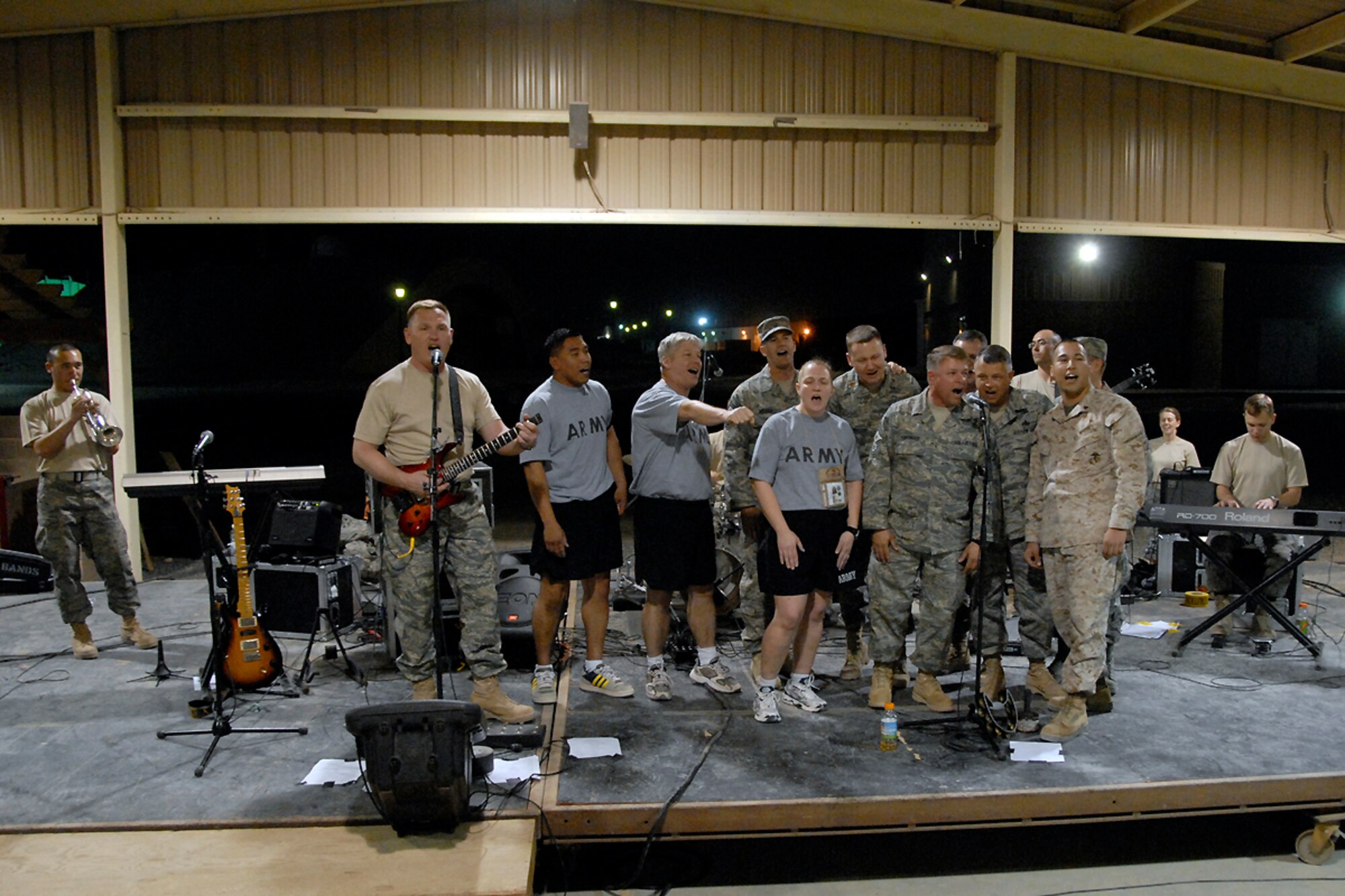 SOUTHWEST ASIA -- A group of Airmen, Soldiers and a Marine from the audience of U.S. and coalition forces joined the U.S. Air Force Central Command Band called 'Falcon' on stage to sing 'American Pie' during their May 15, 2008 performance at an air base in the Persian Gulf Region.  The Falcon Band recently kicked off a 60-day tour throughout Southwest Asia and the Horn of Africa to positively promote troop morale, diplomacy and outreach to host nation communities. (U.S. Air Force photo/Tech. Sgt. Michael O'Connor)