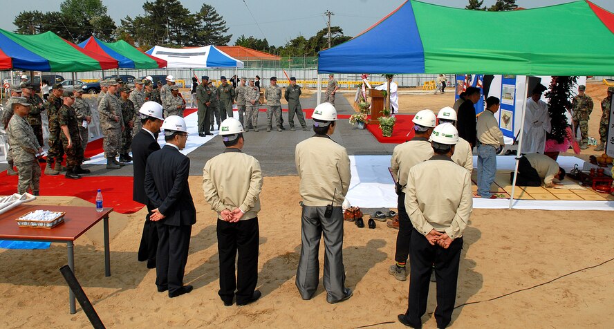 KUNSAN AIR BASE, Republic of Korea -- Base officials and Army Corps of Engineers
assigned here team with a local construction company participate in the Korean Gosa Ceremony after the ground breaking ceremony here May 21. The ceremony marked the beginning of a “Dorms-4-Airmen” project, which is scheduled to be completed in September 2010. The Gosa is a traditional Korean ceremony conducted at the commencement of a new business or construction endeavor to bring safety and prosperity to all involved. The project is part of the Air Force's initiative to improve the quality of life for Airmen.  (U.S. Air Force photo/Senior Airman Giang Nguyen)