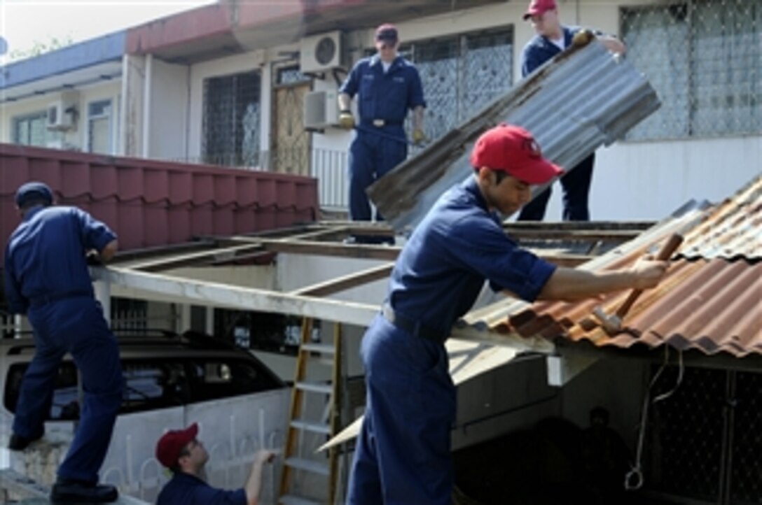 U.S. Navy sailors take down an old leaky roof at the Rumah Bakti Harapan home for special needs children during a community relations project in Inanam, Malaysia, on May 19 2008.  The sailors will replace the roof using newer stronger materials.  