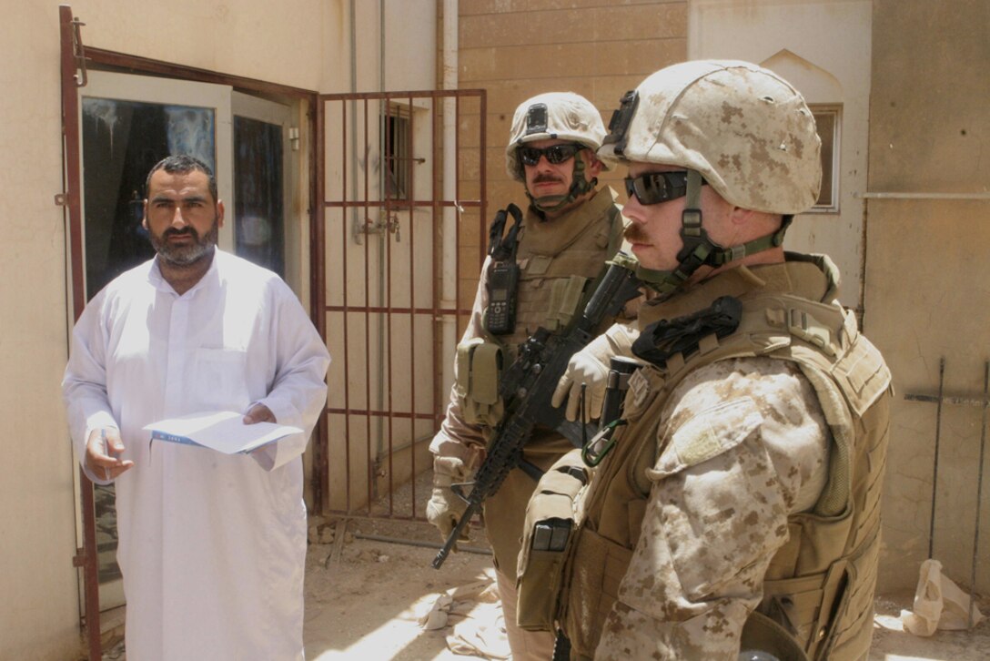 1st Lt. Daniel M. Thomas, team leader, and Gunnery Sgt. Gary M. Gonzales, assistant team leader, both with Detachment 1, Civil Affairs Team 5, 2nd Battalion, 11th Marine Regiment, Regimental Combat Team 5, inspect the outside of a building in Anah, Iraq, May 20, that is being refurbished as a hotel. The building was previously being used by Coalition forces as a combat outpost and joint community center. After the building was demilitarized, the CA team put together a project to do basic repairs on the structure before giving it back to the local government.