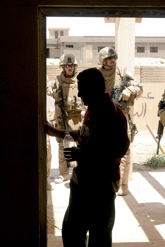 A local contractor from the city of Anah, Iraq, inspects the doorway of a building he has been hired to repair May 20. He and several Marines with Detachment 1, Civil Affairs Team 5, 2nd Battalion, 11th Marine Regiment, Regimental Combat Team 5 walked through the building to list the repairs that would be needed for the upcoming project to refurbish the old combat outpost as a functioning hotel.  After the outpost was demilitarized, the CA team started a project to repair most of the major problems before turning it back over to the local government.