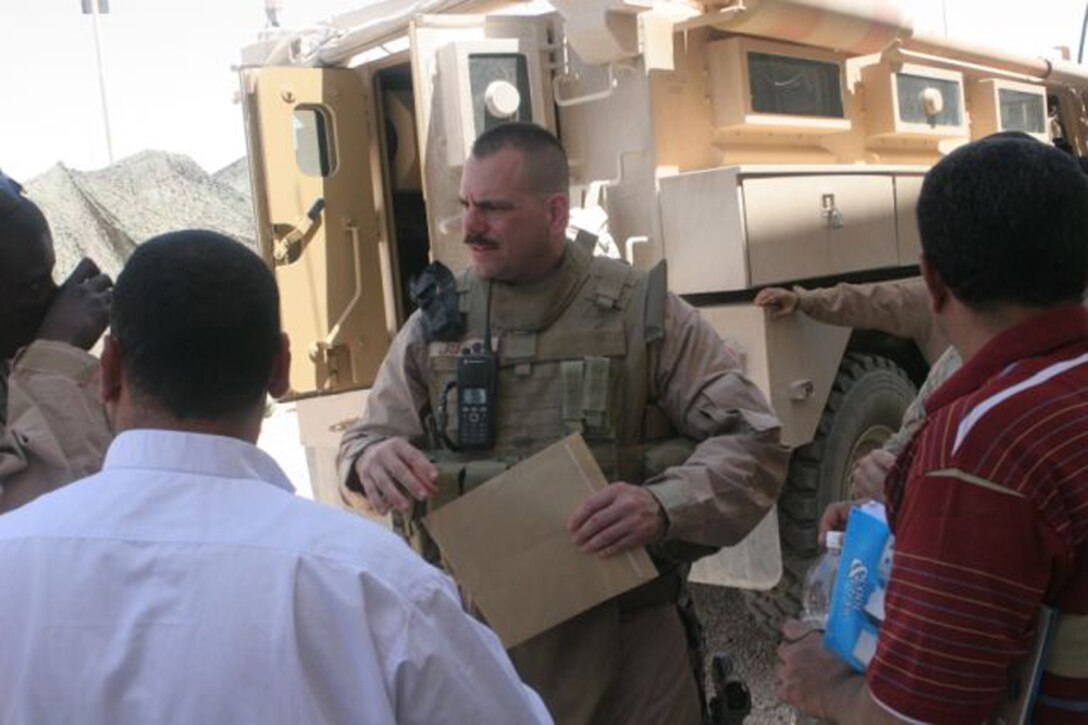 Gunnery Sgt. Gary M. Gonzalez, 39, from Alhambra Calif., who is the civil affairs staff noncommissioned officer in charge of Detachment 1, Civil Affairs Team 5, 2nd Battalion, 11th Marine Regiment, Regimental Combat Team 5, talks with a contractor and an engineer in the city of Anah, Iraq, May 29, about a project for the city. Gonzalez has been doing civil affairs work since 1994 and this is his second time to work in the Anah area.