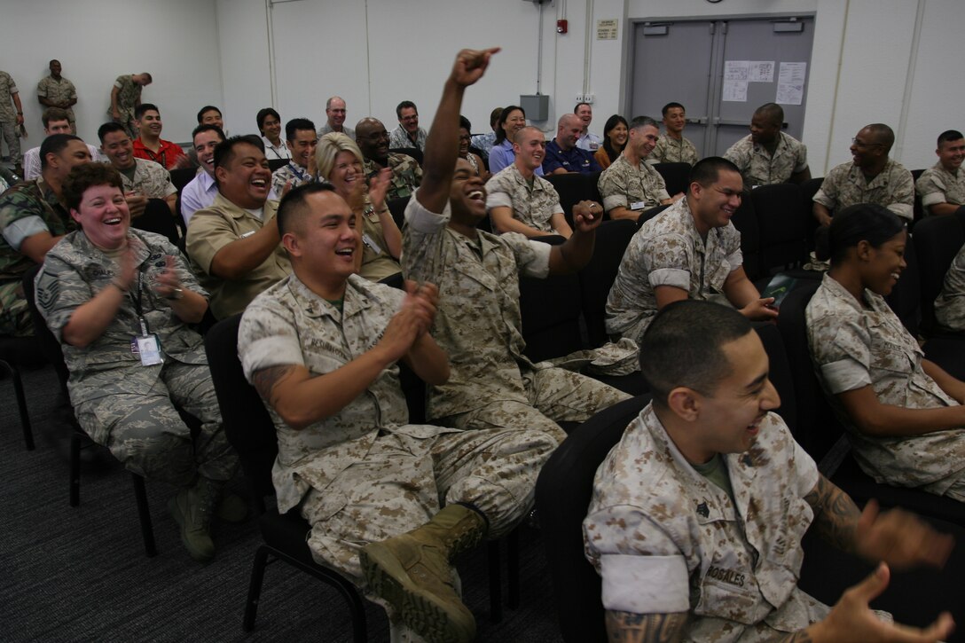 Service members and civilian employees laugh and cheer for Stevie during the Stevie Springer Show. The show was a skit performed by Steve Verret during a driving safety brief May 22 at the Marine Forces Pacific Headquarters Building, Camp H M Smith. Verret is a comedian and traffic safety specialist.