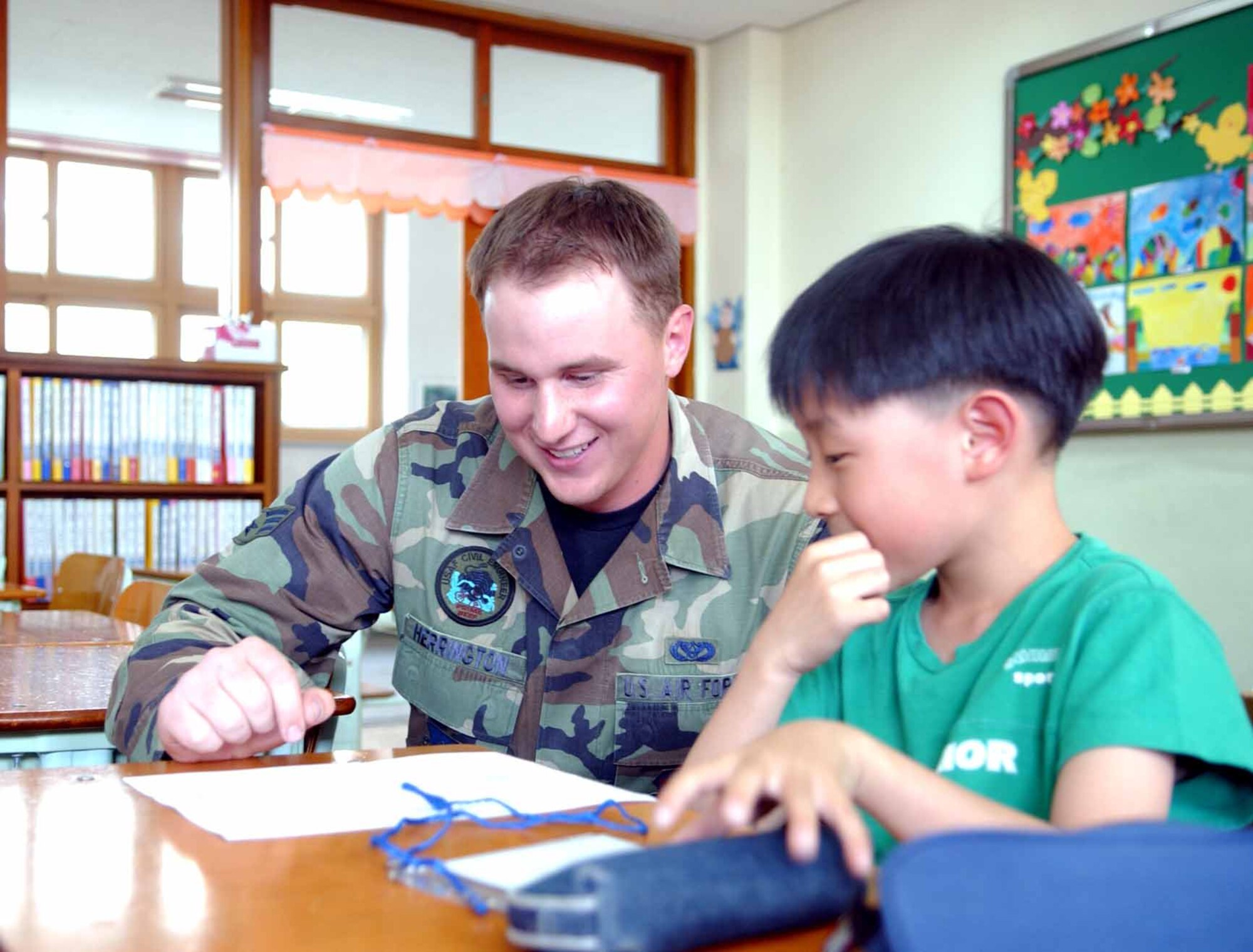 PYONGTAEK CITY, Republic of Korea -- Senior Airman Daniel Herrington, 51st Civil Engineer Squadron, helps a Dongsak Elementary School student with his English lesson during a visit to the school. The visit is part of the 51st Fighter Wing’s Adopt-A-School program, where volunteers lead a two-hour English-conventional class. (U.S. Air Force photo/Tech. Sgt. Matt Summers)