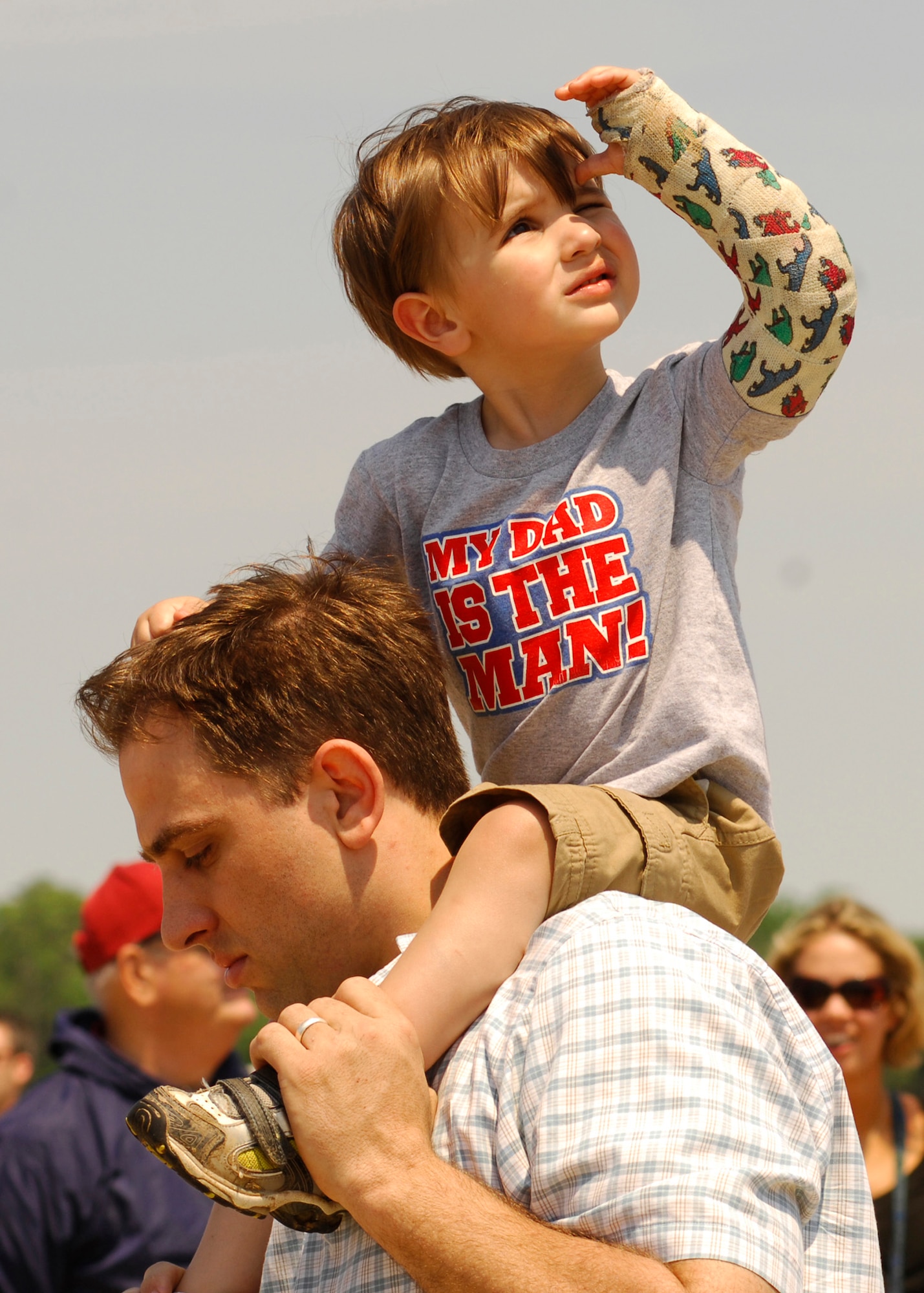Logan Rearick watches the sky for the F-22 Raptor, while his dad Jason Rearick carries him at the 2008 Joint Service Open House hosted by Andrews Air Force Base, Md., May 17th.   This year?s event will have demonstrations by the Navy Blue Angels and the Army's Golden Knights.  Once again the JSOH will host a wide variety of both military and civilian air and ground demonstrations. To include the Air Force's newest and the world's most advanced fighter jet, the F-22A Raptor. (U.S. Air Force photo by Tech Sgt. Suzanne M. Day)
