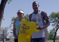 CANNON AIR FORCE BASE N.M.-- Kathy Leahy and Staff Sgt. Eric Schmidt, 27th Special Operations Civil Engineer Squadron, display a t-shirt and the trophies they won the top runners in their categories of the annual Gate-to-Gate Run on May 22.  Airmen and civilians ran 5.5 miles to honor fallen warriors as part of the upcoming Memorial Day observances.  (U.S. Air Force photo by Airman 1st Class James R. Bell)