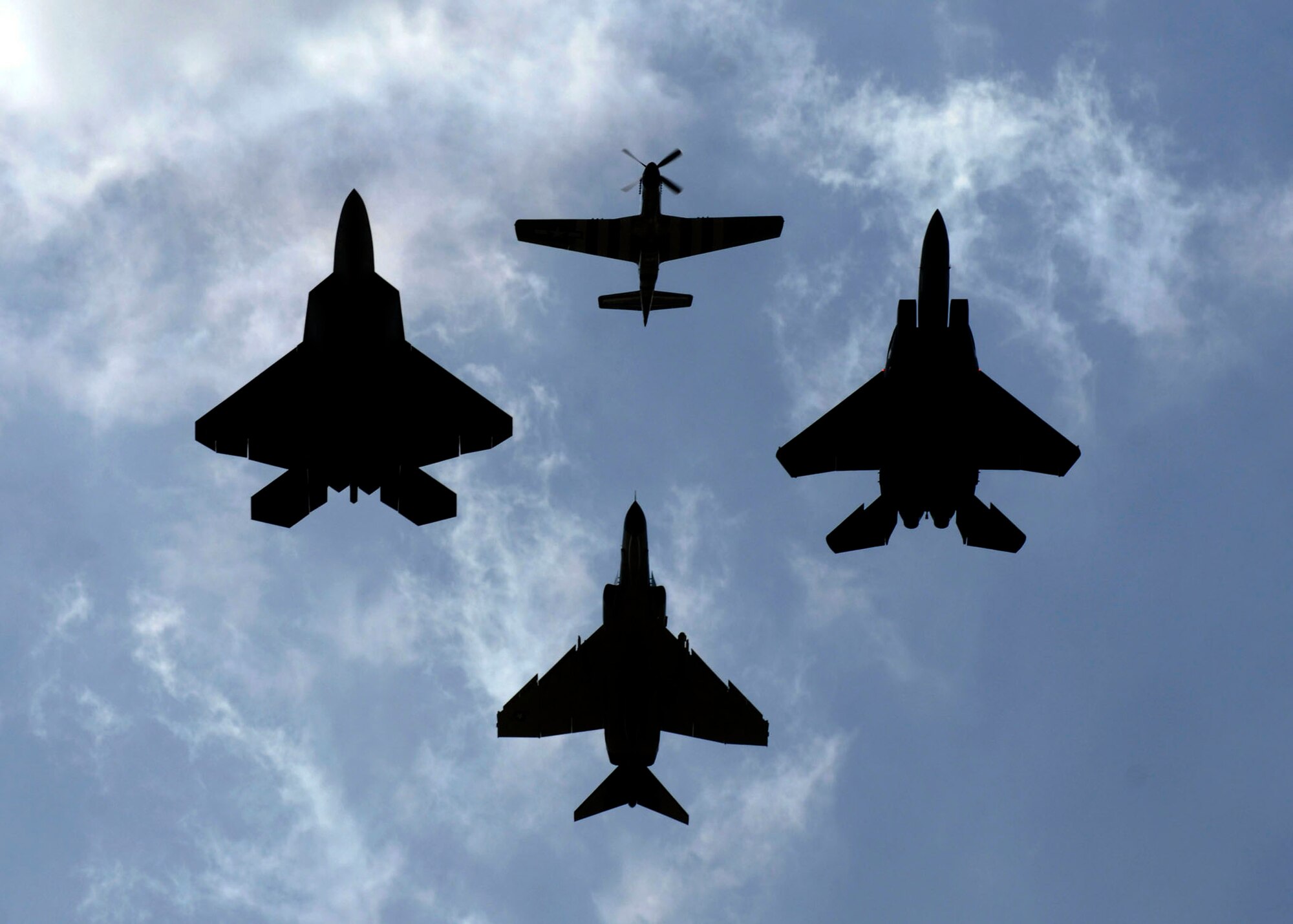 (Clockwise) A P-51 Mustang, F-15 Strike Eagle, F-4 Phantom and an F-22 Raptor fly together during a heritage flight over Andrews Air Force Base during its annual Joint Service Open House May 17.  The 2008 JSOH commemorated the 60th Anniversary of the Berlin Airlift and showcased the Navy Blue Angels, the Army's Golden Knights and a wide variety of both military and civilian air and ground demonstrations. (U.S. Air Force photo/Senior Airman Steven R. Doty)