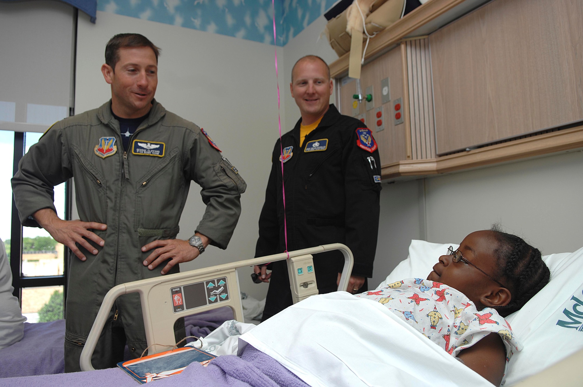 FLORENCE, S.C.-- Capt. George Clifford, pilot, and Master Sgt. Bryan Spangler, team chief, both members of the F-16 Viper East Demonstration Team, wish a quick recovery and talk about the Florence air show, May Fly, to seven-year-old Malaysia Patterson, daughter of Brenda Patterson, at McLeod Regional Medical Center May 22. The 20th Fighter Wing at Shaw Air Force Base, S.C., is home to the Viper East Demonstration Team, one of two single-ship F-16 aerial demonstration teams in Air Combat Command. The 338th FW at Hill AFB, Utah, is home to the Viper West Coast Demonstration Team. (U.S. Air Force photo/Staff Sgt. Nathan Bevier)