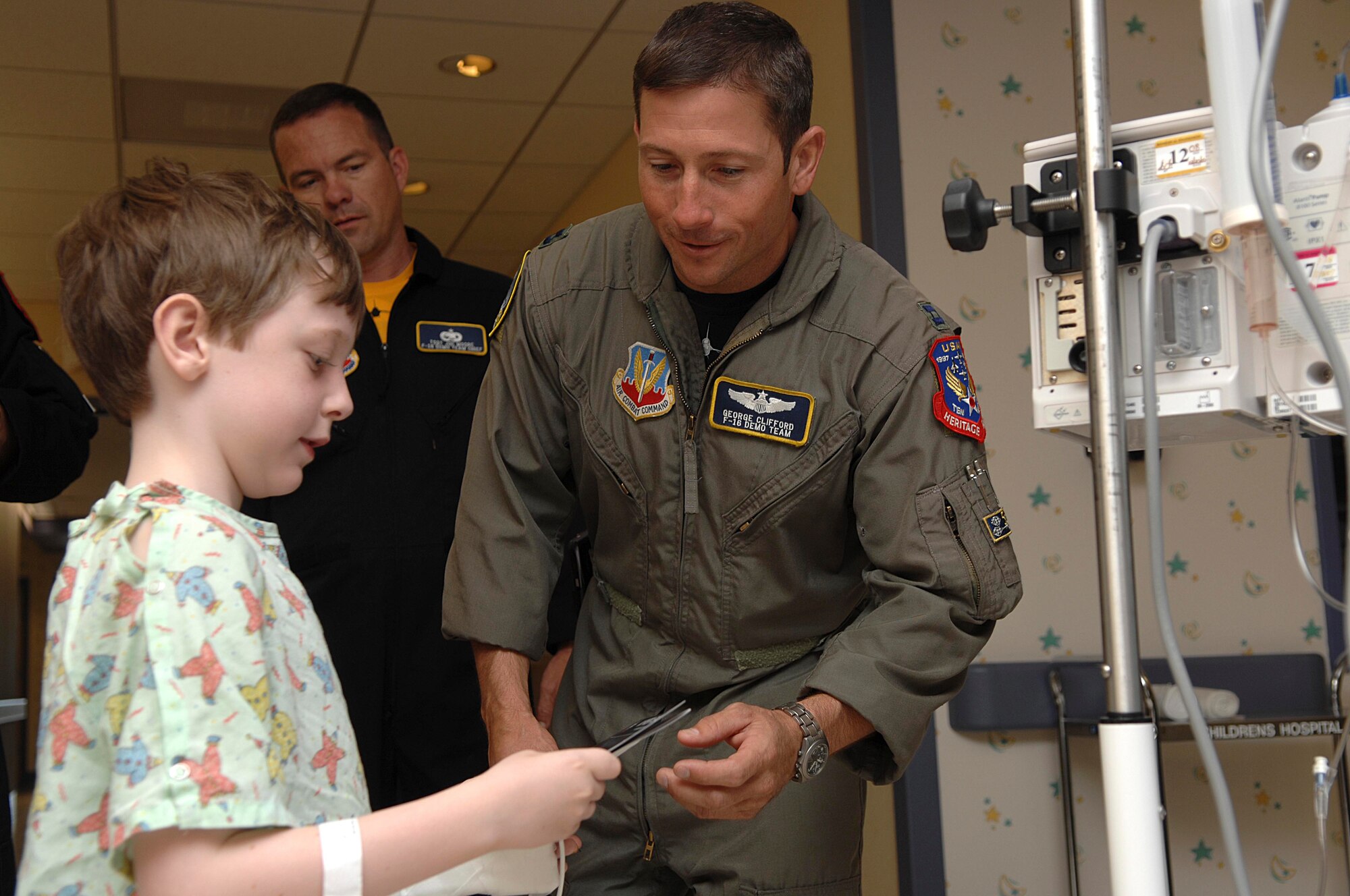 FLORENCE, S.C.-- Capt. George Clifford, F-16 Viper East Demonstration Team pilot, gives 7-year-old Luca Ammirati, son of Emily Ammirati, Viper East stickers and coloring booklet at McLeod Regional Medical Center May 22. Tech. Sgt. Joe Moore, Viper East team chief, looks on from the background. The 20th Fighter Wing at Shaw Air Force Base, S.C., is home to the Viper East Demonstration Team, one of two single-ship, F-16 aerial demonstration teams in Air Combat Command. The 338th FW at Hill AFB, Utah, is home to the Viper West Coast Demonstration Team.(U.S. Air Force photo/Staff Sgt. Nathan Bevier)