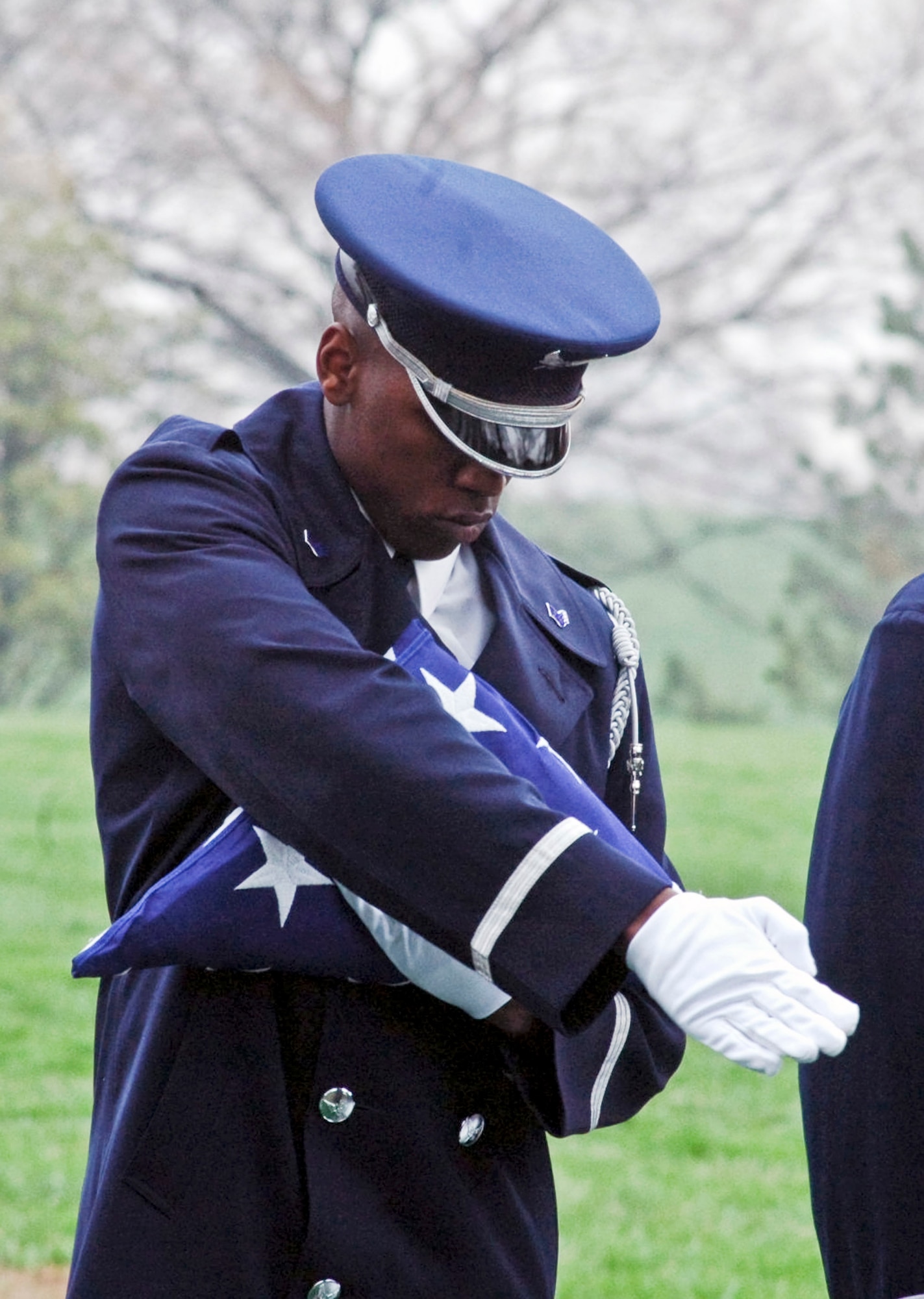 An Airman from the U.S. Air Force Honor Guard participates in a flag-folding ceremony during a funeral at Arlington National Cemetery, Va. (U.S. Air Force photo/Tech. Sgt. Scott T. Sturkol)