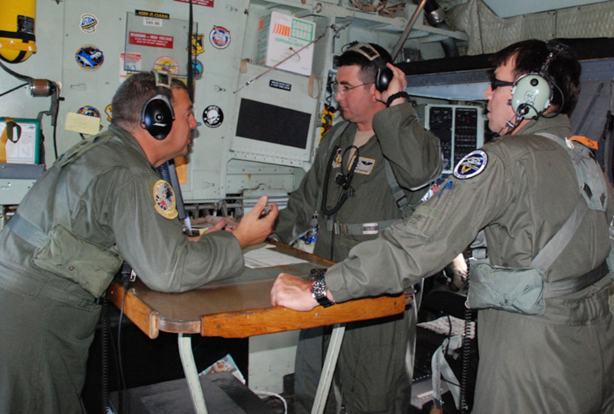 PATRICK AIR FORCE BASE, Fla. -- Lt. Col. Roger Gibson (left) conducts "Airboss" training with Capt. Steve Sartain (center) while Col. Richard Breitbach observes the action.  The training took place aboard a HC-130P/N during a recent Mode 8 search and rescue exercise. Gibson and Sartain are with the 920th Rescue Wing while Breitbach is from Headquarters Air Force Reserve Command.  Colonel Breitbach was observing operations from a Headquarters point of view to better understand the resources that AFRC contributed to the mission and to advocate the role of the combat rescue officer on the mission.  (U.S. Air Force photo/Capt. Cathleen Snow)