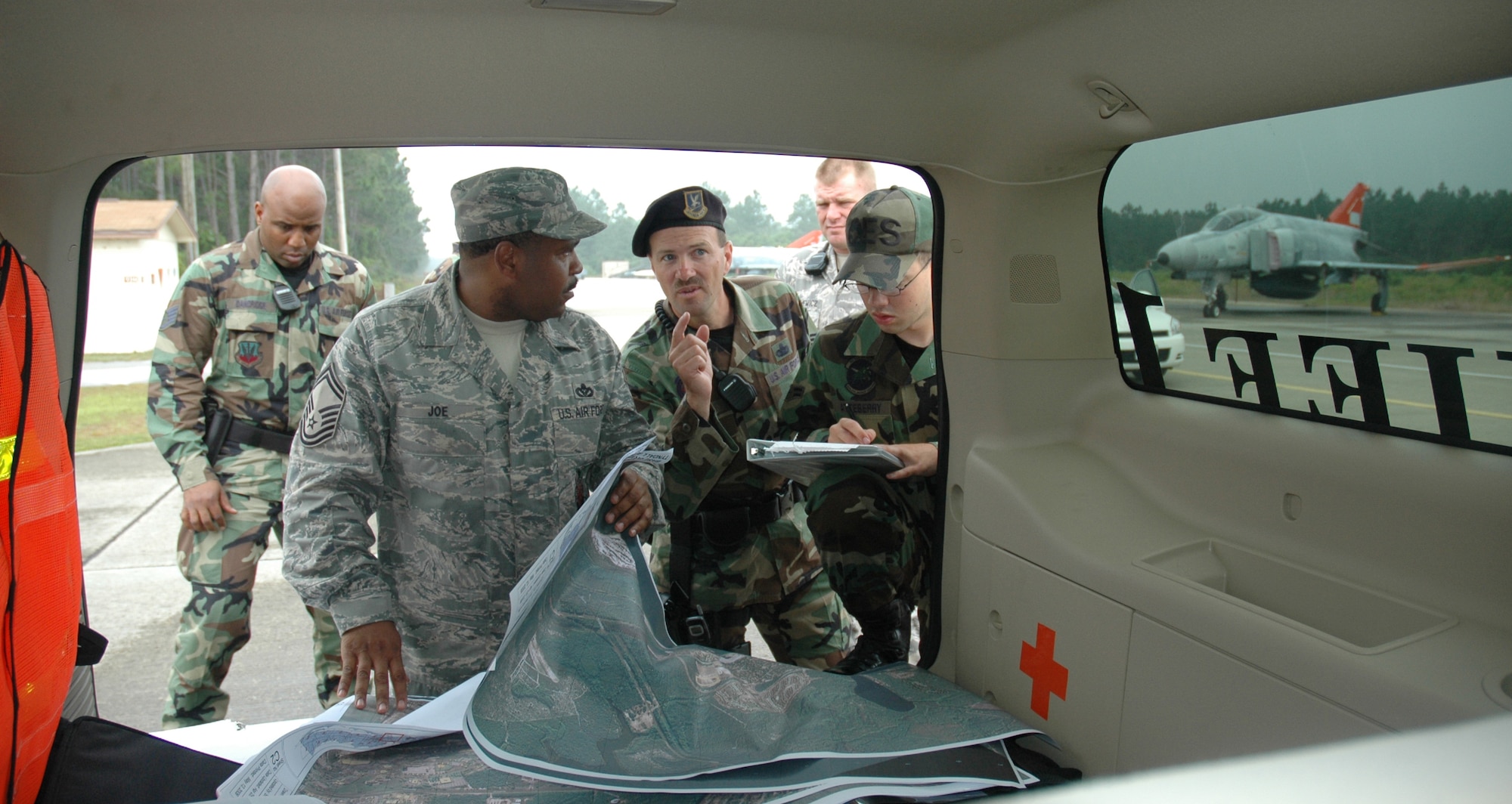 Senior Master Sgt. Derrick Joe, 325th Civil Engineer Fire and Emergency Services deputy chief and Master Sgt. Tim Abbey, 325th Security Forces Squadron day flight chief, discuss the response of their forces during the major accident response exercise May 16.  (U.S. Air Force photo/Staff Sgt. Timothy R. Capling)