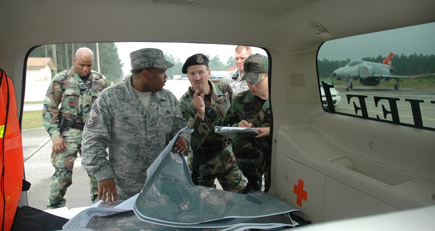 Senior Master Sgt. Derrick Joe, 325th Civil Engineer Fire and Emergency Services deputy chief and Master Sgt. Tim Abbey, 325th Security Forces Squadron day flight chief, discuss the response of their forces during the major accident response exercise May 16.  (U.S. Air Force photo/Staff Sgt. Timothy R. Capling)