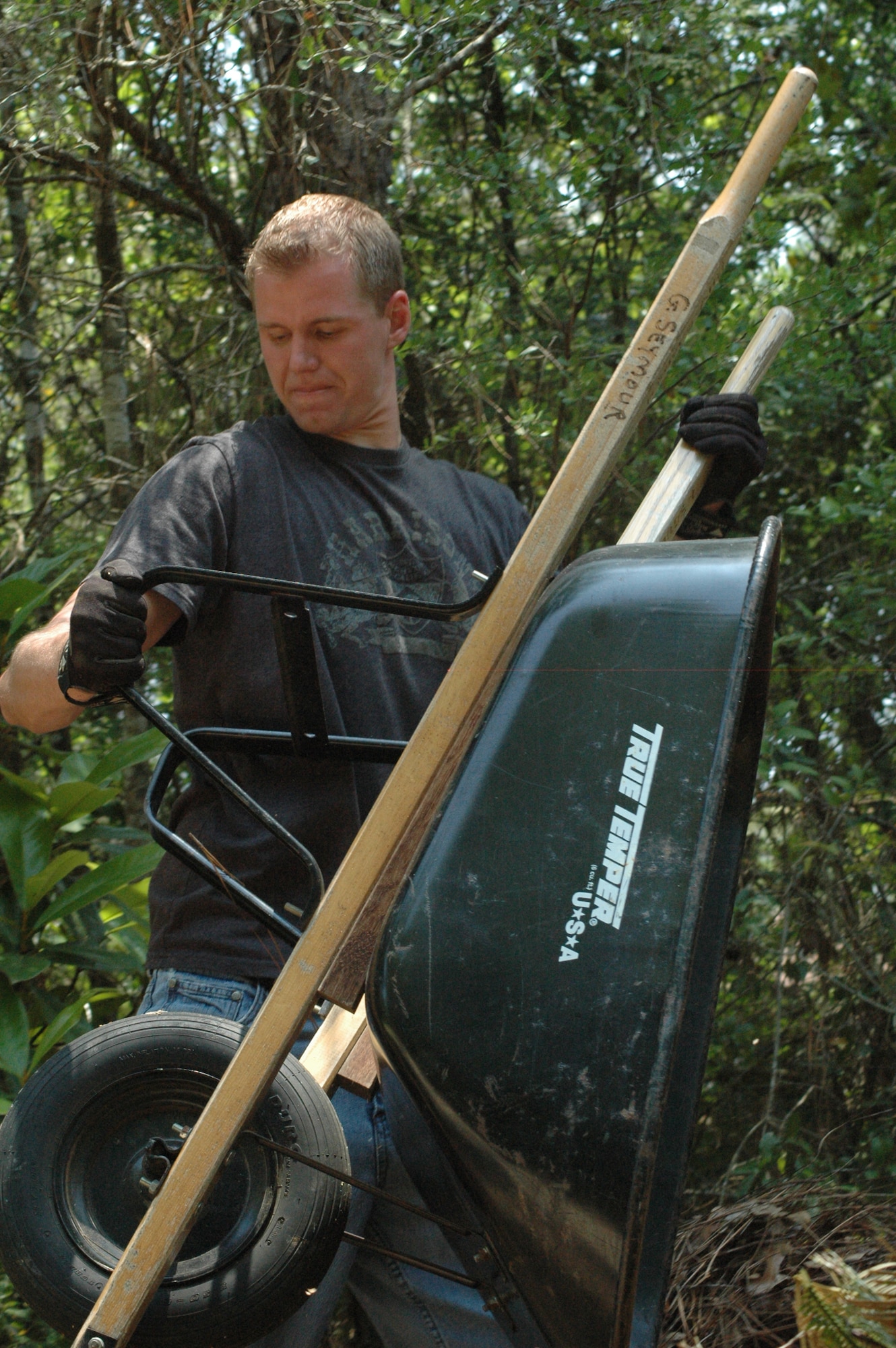 EGLIN AIR FORCE BASE -- Staff Sgt. Ryan Mozingo, 33rd Fighter Wing's 728th Air Controll Squadron, empties a barrel of pine needles he raked up while gardening for the Bob Hope Village Cleanup May 21. This was a volunteer event aimed to help the residents of Bob Hope Village.
