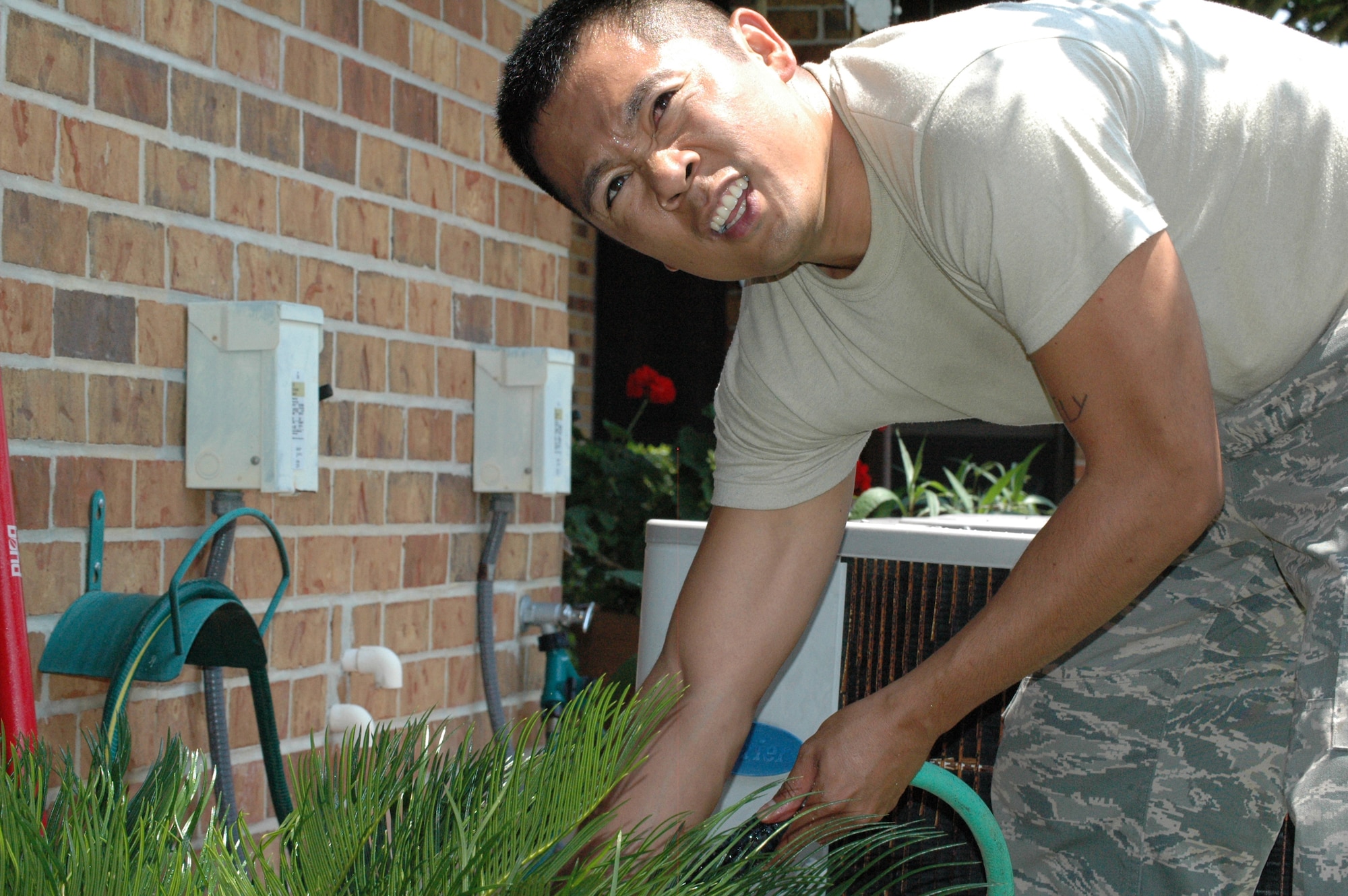 EGLIN AIR FORCE BASE -- Staff Sgt. Adonis Carbarle, Air Armament Center Equal Opportunity, plants palm trees for a resident of Bob Hope Village. This was for a volunteer clean up to help widows/surviving spouses with minor chores to help make life a little bit easier.
