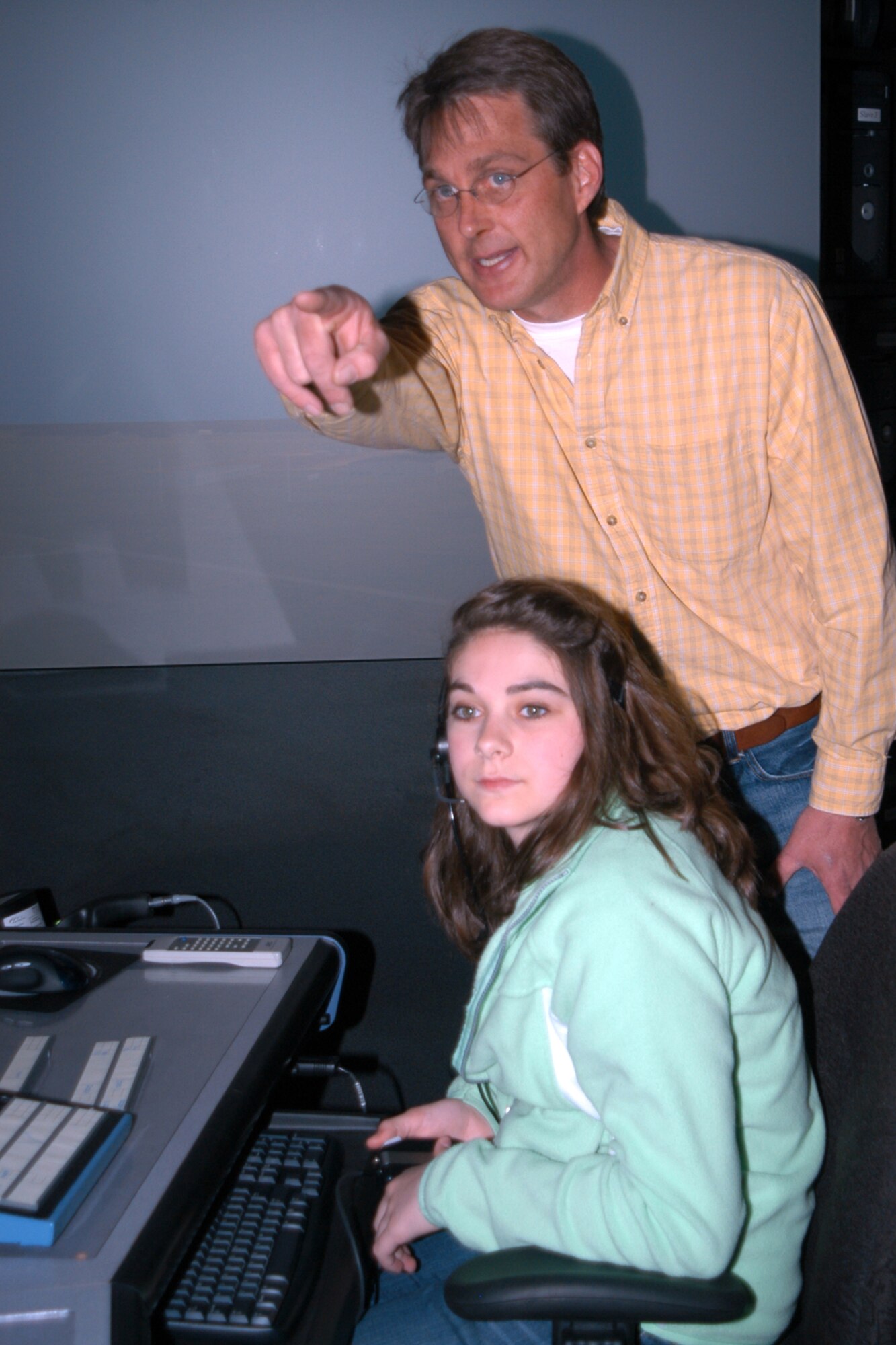 GRISSOM AIR RESERVE BASE, Ind., -- Robert Moore, an air traffic control/standardization manager, points to an aircraft on the air traffic control tower simulation system, as Laura Fields, a member of the Peru Mayor's Youth Leadership Council, manages ground traffic.  Grissom hosted the mayor and students in the leadership council  May 22. (Air Force photo/Senior Airman Ben Mota)