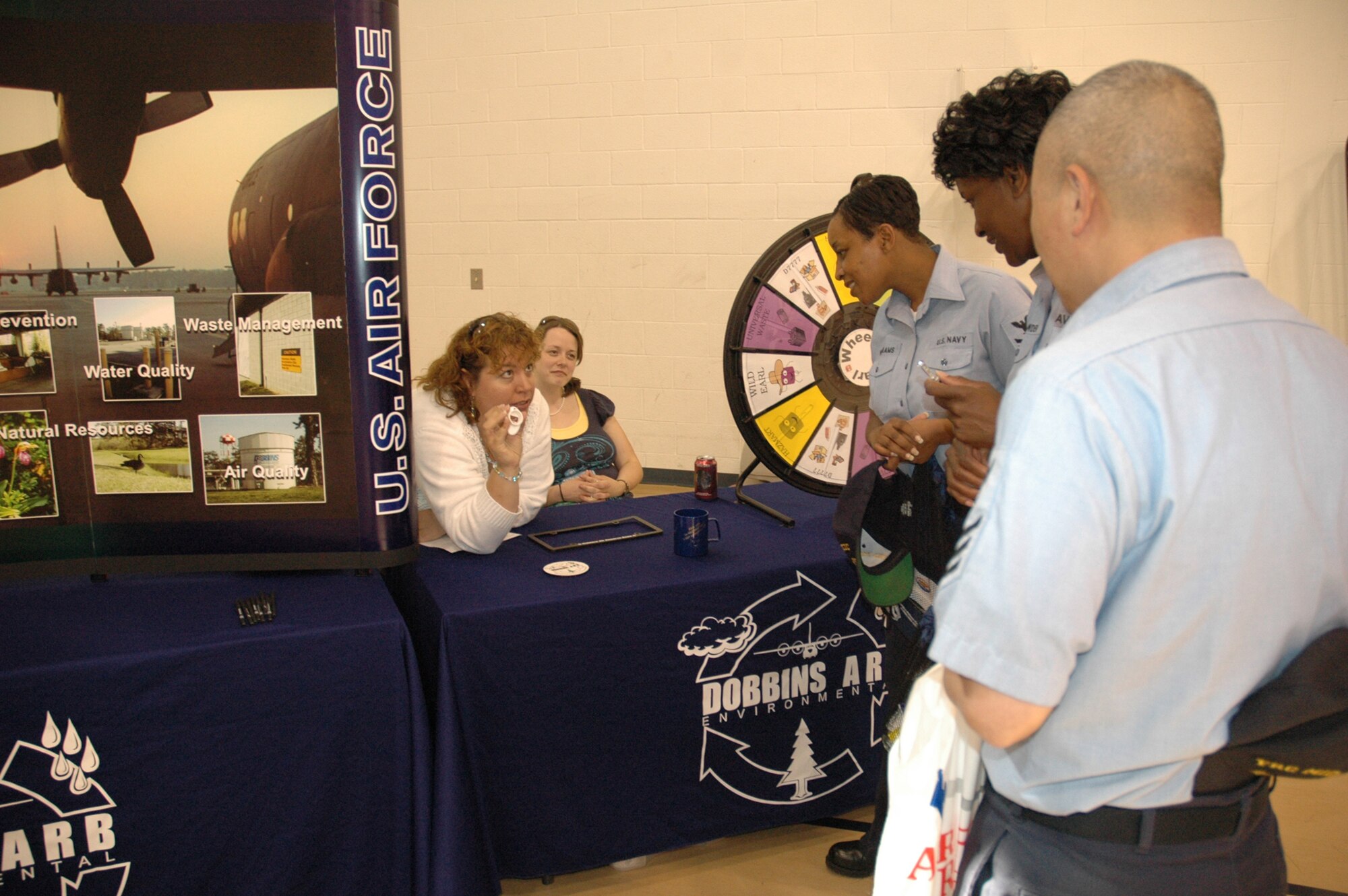 Gina Rose, left, and Kim Bailey, center, of the Dobbins Civil Engineer Environmental Management office educate Navy personnel on the proper disposal of Hazardous Materials at the Joint Safety and Health Fair put on by the respective safety offices and volunteers at Dobbins Air Reserve Base and Naval Air Station Atlanta May 22. There were information booths on everything from dangerous snakes to the proper wear of ear plugs. (Air Force photo/Micah Garbarino)