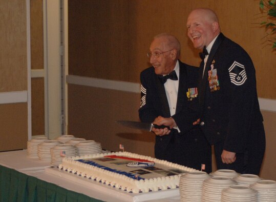 Retired Chief Master Sgt. Gino Conti and Senior Master Sgt. James McCarty, the most senior and junior ranking chiefs in attendance, cut the cake at McCarty's recognition ceremony Wednesday after dinner. (U.S. Air Force photo by Airman Josh Harbin)