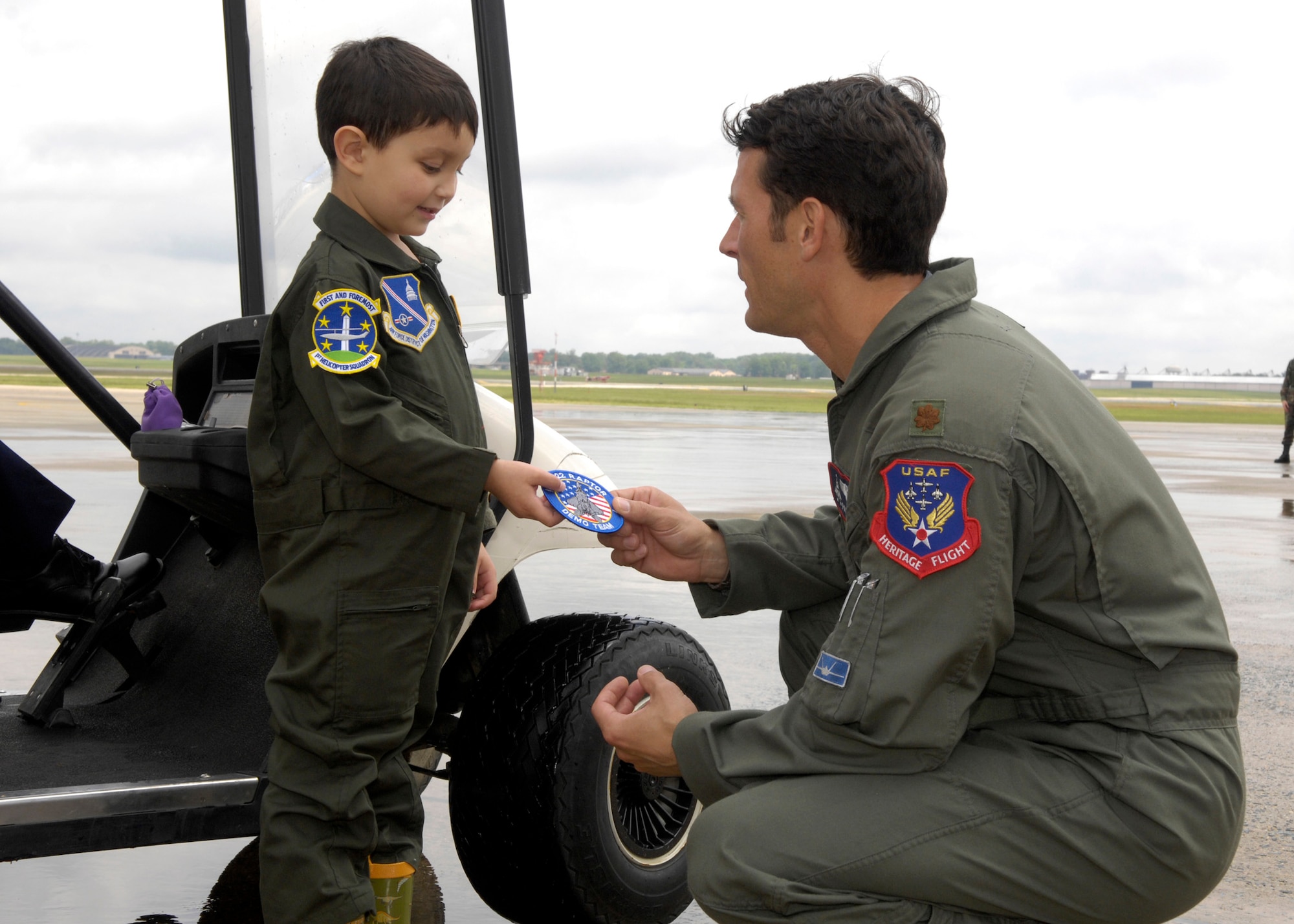 Major Max Moga, pilot of the F-22 Raptor gives a patch to Brandon Leach during his tour of the aircraft at Andrews Air Force Base Md., on May 16, 2008. The team is here from Langley Air Force Base, Vir. as a part of the Joint Service Open House. (U.S. Air Force photo by Senior Airman Renae Kleckner)(released)