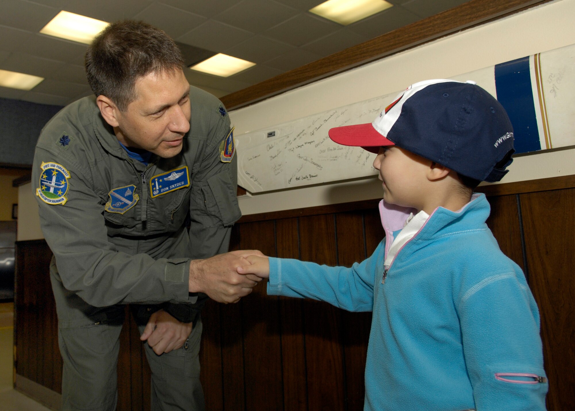 Lt Col Donald Snyder, 1st Helicopter Squadron Commander, shakes hand with Brandon Leach, the "Pilot for a Day" upon his arrival to Hangar 1 at Andrews Air Force Base, Md., on May 16, 2008. Michael got a tour from the 1st Helicopter Squadron as well as various parts of the Open House such as the F-22 Raptor and the Blue Angels. (U.S. Air Force photo by Senior Airman Renae Kleckner)(released)