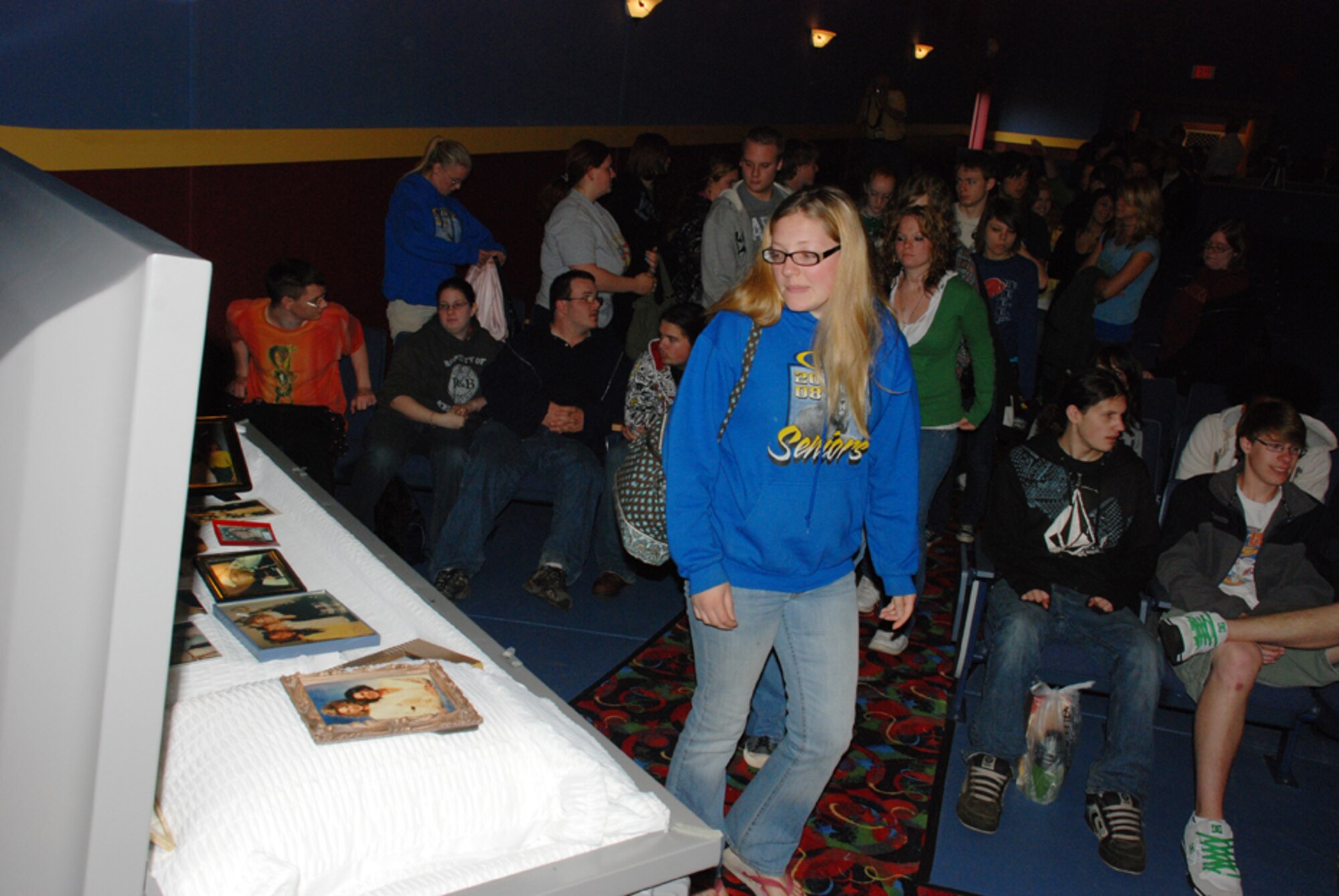 Lockport high school student walks by a casket filled with photos of a girl who died in a drinking and driving accident.  This experience is part of the victim impact panel.  Before the students walk by the casket, a loved one of the deceased talks to the students about their loss.  (U.S. Air Force photo/Staff Sgt. Rebecca Kenyon).
