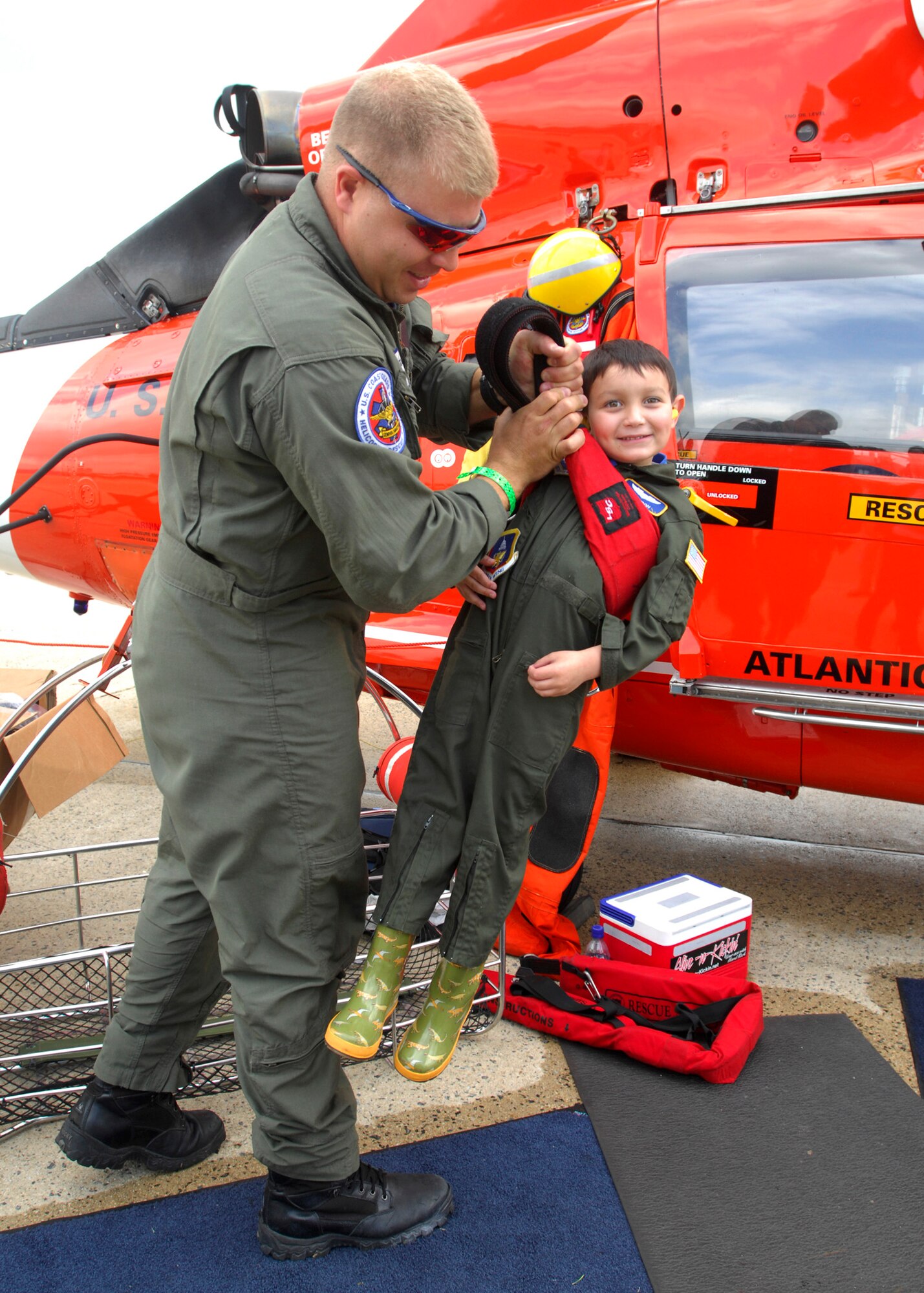 Aviation Survival Technician 2 (E-5) Tye Conklin, US Coast Guard, shows Brandon Leach, Pilot for a day, what its like being lifted out the water by the harness that is attached to a hook on the helicopter on 16 May 2008 at the Joint Service Open House Air Show held on Andrews AFB, MD. (USAF Photo by Senior Airman Melissa Stonecipher)