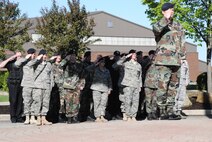YOUNGSTOWN AIR RESERVE STATION, Ohio - 910th Security Forces Personnel stand saluting in the shadow of the flag as it is lowered to half mast in honor of fallen security forces troops and police officers. U.S. Air Force photo by Mr. Eric M. White